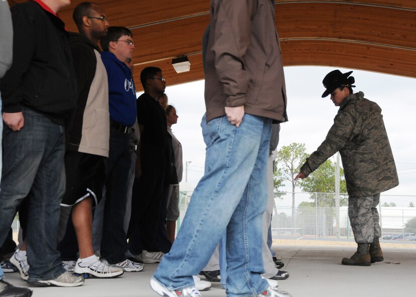 Master Sgt. Tiffany Lopez, 96th Force Support Squadron, directs a recruit to adjust their feet while practicing facing movements Feb. 6 at Duke Field.  Sergeant Lopez and her husband, Tech. Sgt. Raul Lopez, 96th Logistics Readiness Squadron, both former active-duty military training instructors at Lackland AFB, Texas, volunteered their time to help new reserve recruits prepare for basic training during the drill weekend here.  The husband and wife team spent four years instructing new trainees at Lackland, graduating 25 flights from Basic Military Training.  (U.S. Air Force photo/Tech. Sgt. Samuel King Jr.)