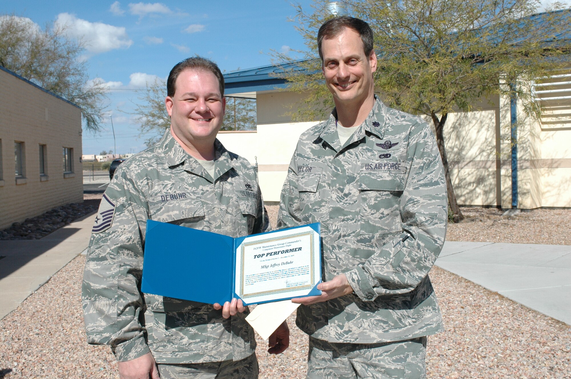 Master Sgt. Jeffrey DeBuhr, (left) component maintenance flight, receives the Elite Performer award from Lt. Col. James Taylor, 162nd Maintenance Group commander, Feb. 4.  Sergeant DeBuhr was chosen for the award from 800 Guardsmen that serve in the maintenance group here.  The award recognizes maintainers who consistently perform quality work, maintain safe work practices, follow technical data, and engage in quality initiatives.  (Air Force photo by Maj. Gabe Johnson)