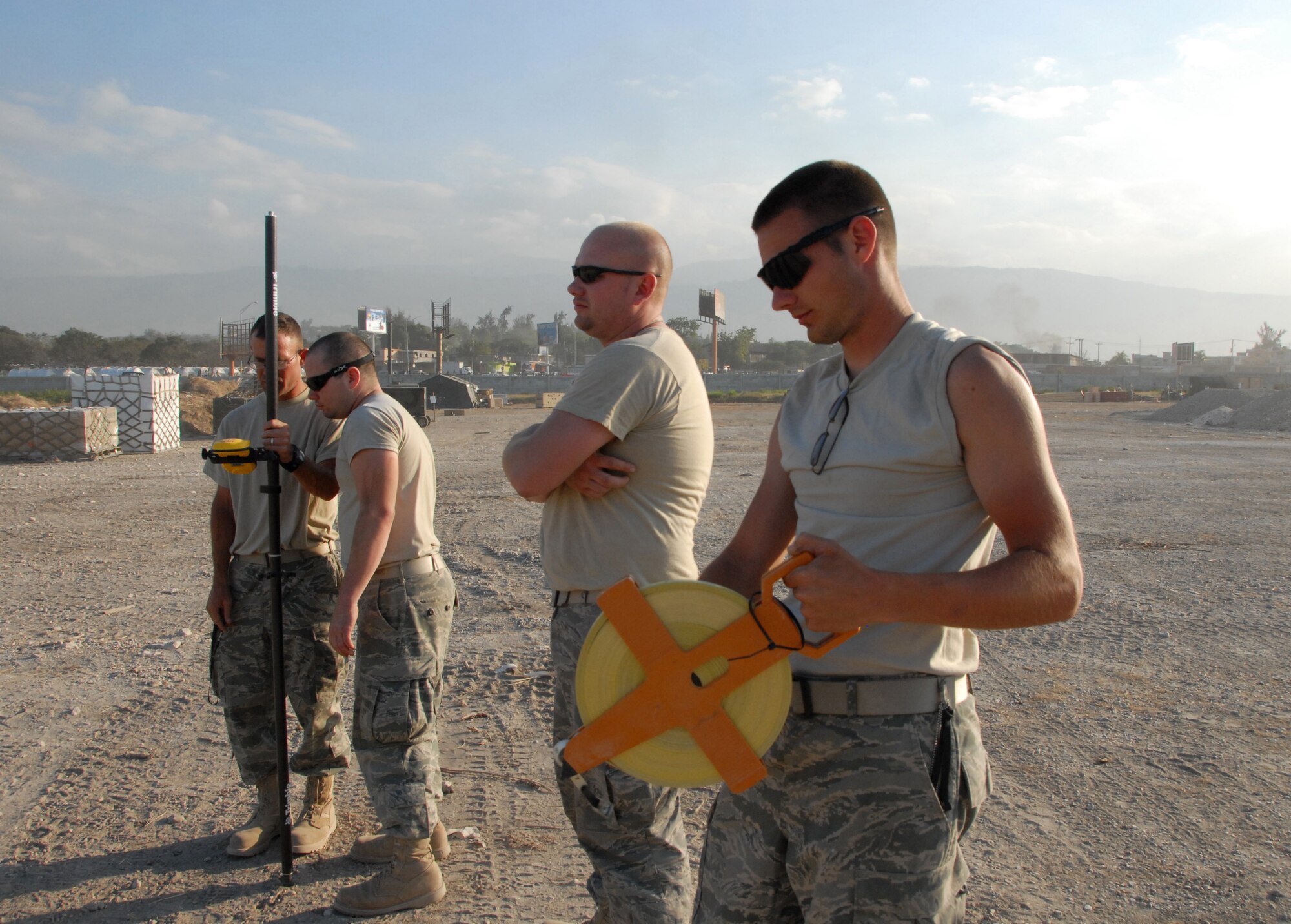 Senior Airman Kristopher P. Stewart (right) rolls measuring tape while surveying a living area for military relief workers, Feb. 2, 2010, at Port-au-Prince airport. Airman Stewart is an engineering assitant with the Kansas Air National Guard's 190th Civil Engineering Squadron. (U.S. Air Force photo/Tech. Sgt. Emily Alley)