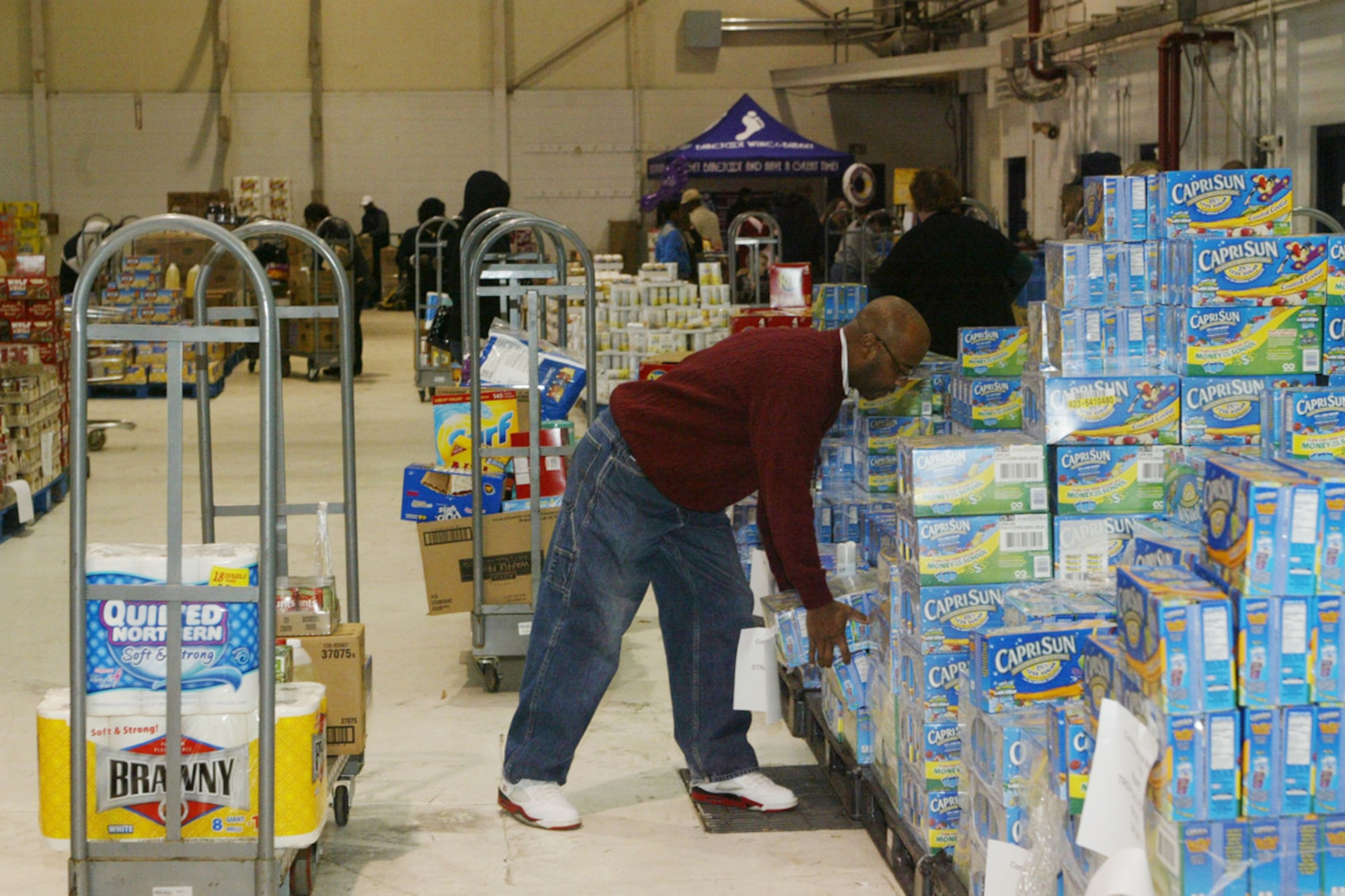 Military members, retirees and dependents take advantage of savings at the case lot sale at Dobbins Air Reserve Base Feb. 6. The Defense Commissary Agency holds periodical case lot sale events, offering customers bulk quantities of their favorite products at increased savings, such as canned goods, beverages, cleaning or laundry products, meat and produce. (U.S. Air Force photo/Don Peek)