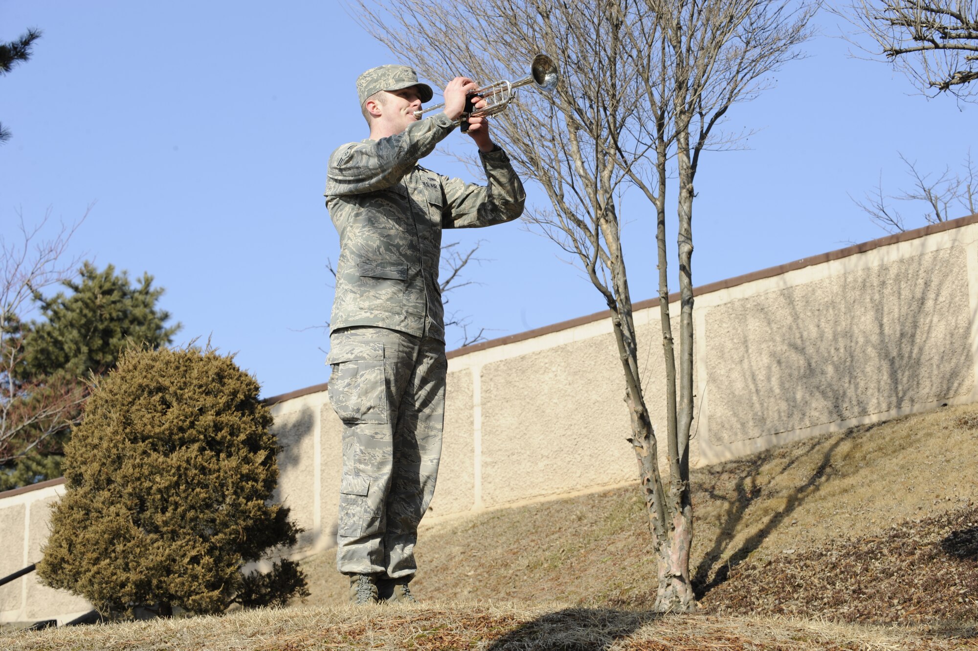 Airman 1st Class Stephen Tritten plays the bugle during an annual remembrance ceremony for Hill 180 "Battle of Bayonet Hill" at Osan Air Base, Republic of Korea, Feb. 5. A1C Tritten is a Network Technichian from the 51 Communications Squadron. His grandfather was one of the soldiers who fought in the Battle of Bayonet Hill 59 years ago.  A crowd of more than 200 people attended the ceremony. Events included a wreath-placing ceremony, a rifle salute and colors presentation by the Osan Air Base Honor Guard. (U.S. Air Force photo/Senior Airman Stephenie Wade) 