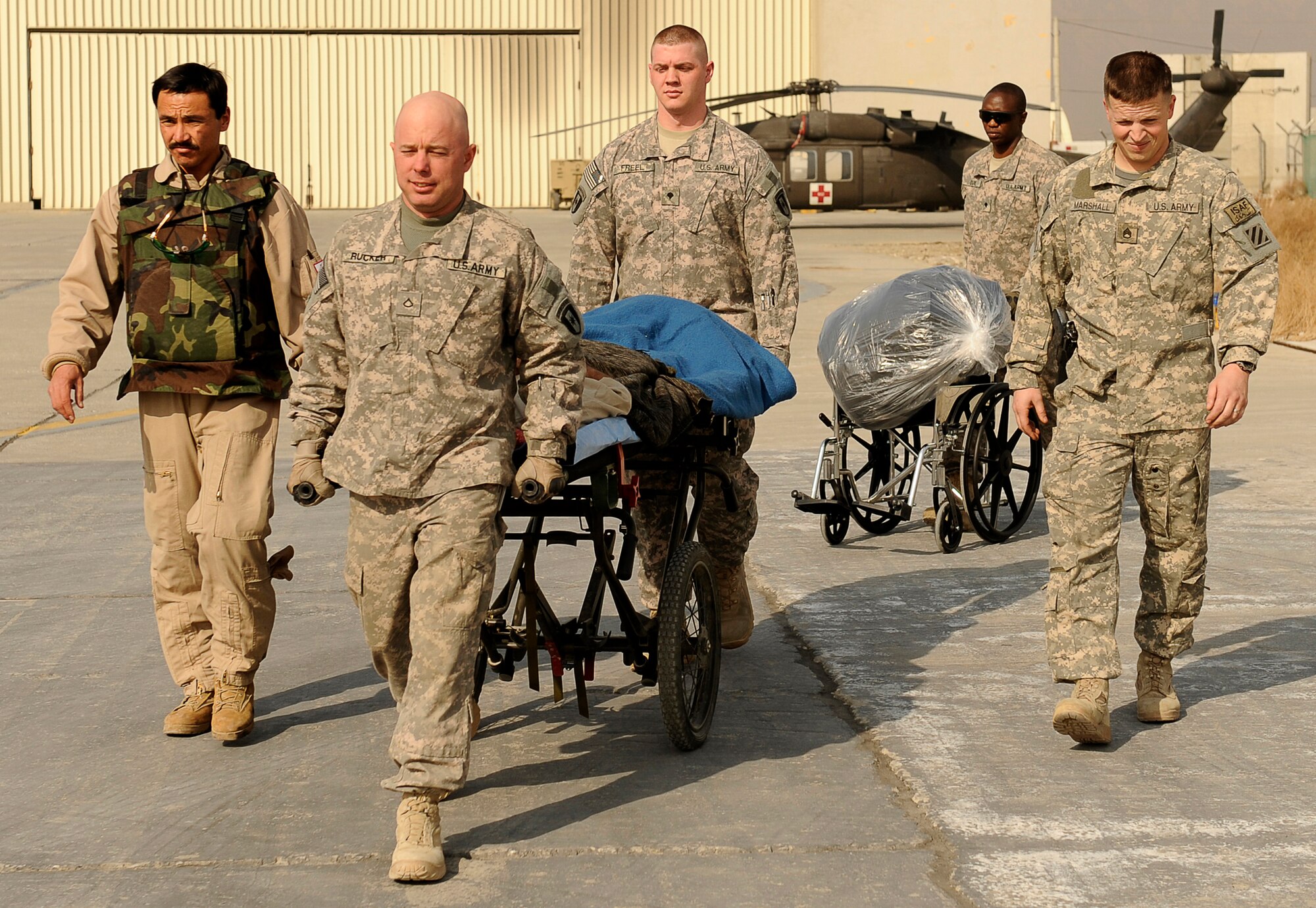 U.S. Army Soldiers from the 36th Air Support Medical Company, and Afghanistan National Army Air Corp Sgt. 1st Class Ghulam Sakhi (left), escort an Afghan soldier on a medical evacuation Feb. 3, 2010, at Bagram Airfield, Afghanistan. Sergeant Sakhi is a flight medic with the 438th Air Expeditionary Advisory Group/Combined Air Power Transition Force. (U.S. Air Force photo/Tech. Sgt. Jeromy K. Cross)