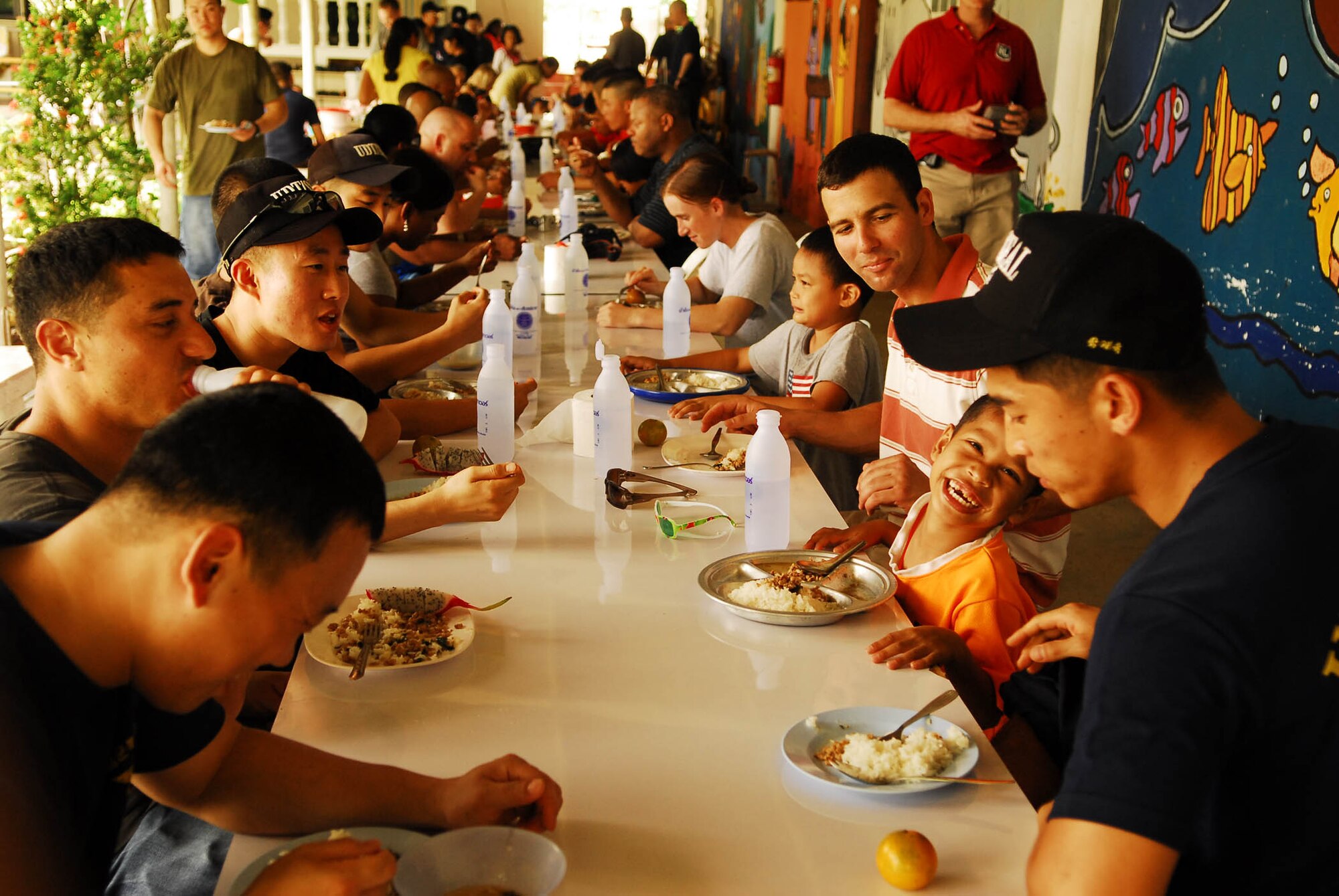 Members of the U.S. Army and Air Force, as well as Republic of Korea Marine Corps and Navy personnel, eat lunch with residents of an emergency center for small children in Pattaya, Thailand, during a joint military community relations project Jan.30. The servicemembers played with the children, attended a lunch cooked by the center's personnel, and landscaped the area.  The visit was part of Exercise Cobra Gold 2010. (U.S. Marine Corps Photo/Cpl. Jovane M. Holland)