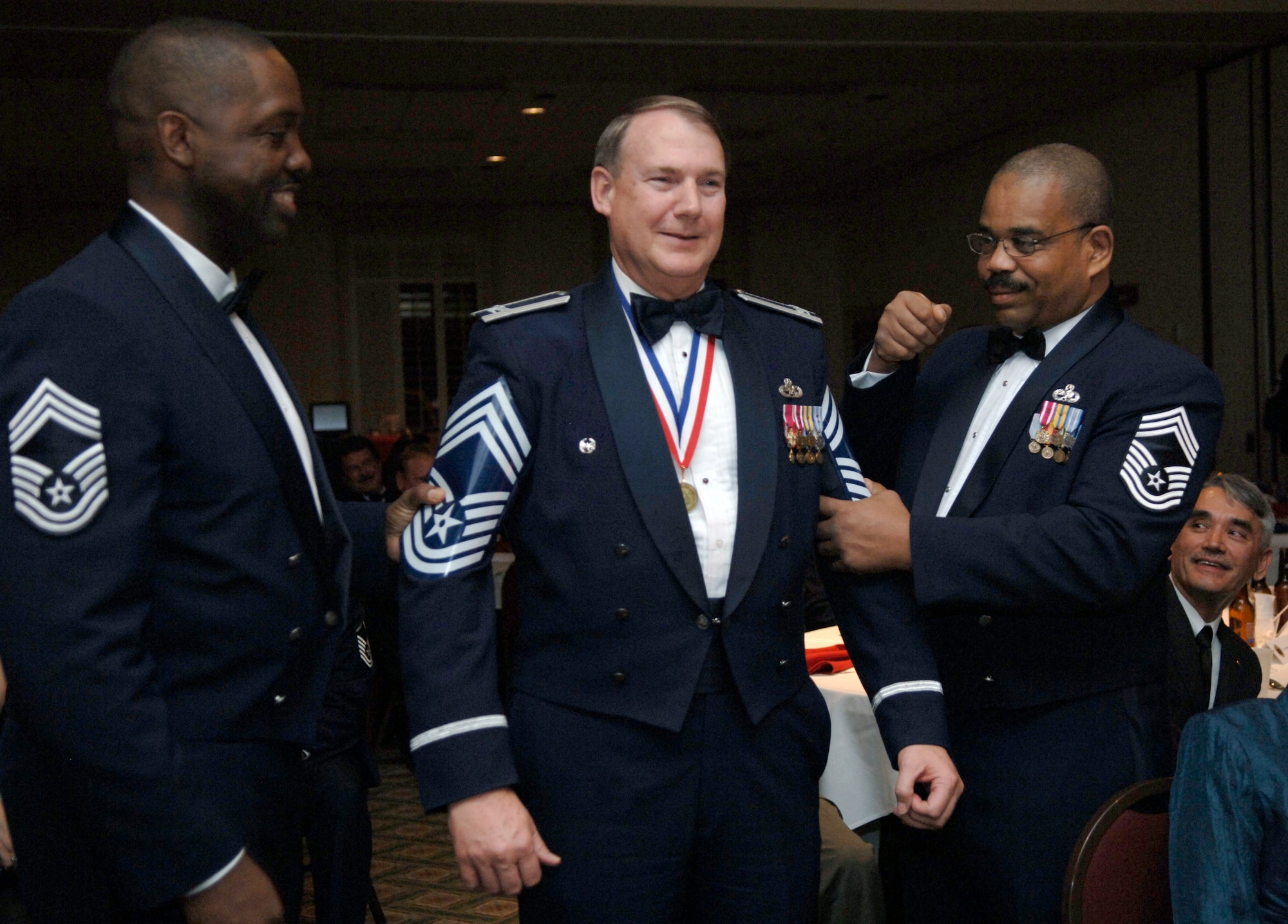 Chief Master Sgt. Chris Riley and retired Chief Master Sgt. Lawrence Strother tack rank on retired Col. Norman Moore at the Annual Charleston Chief's Group Recognition Ceremony held at the Charleston Club Feb. 6. Colonel Moore was recognized for his dedication and contributions to the enlisted force and was made a honorary chief. Chief Riley is the quality assurance superintendent with the 437th Maintenance Operations Squadron. (U.S. Air Force Photo/Airman1st Class Lauren Main)