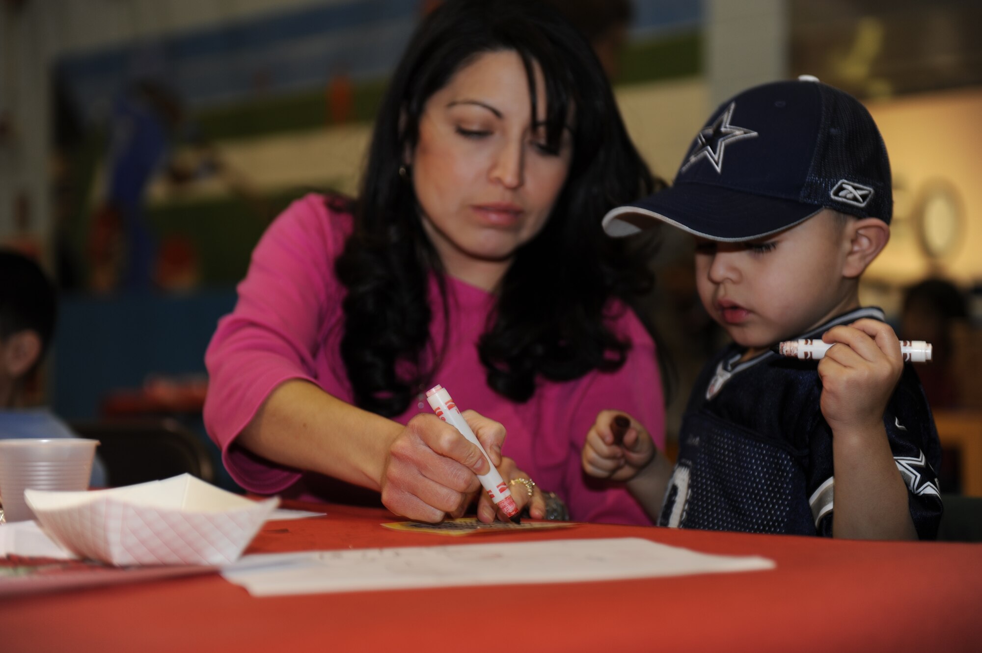 Gabriel Saldena, son of Tech. Sgt. Eric Saldana, 28th Logistics Readiness Squadron NCO-in charge of cargo movement,  currently deployed, plays bingo with his mother, Sonia, during Sweetheart Bingo on Feb 5. The Airman and Family Readiness Center sponsored this event for family members of Airmen either deployed  or on remote assignments. The mission of the Ellsworth AFRC is to have professionals provide versatile and responsive foundations which build readiness, retention and resiliency and lead to personal effectiveness.  (U.S. Air Force photo/Master Sgt. Loren J. Bonser)
