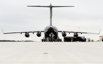 MOODY AIR FORCE BASE, Ga. -- A C-17 Globemaster III from McChord Air Force Base, Wash., refuels while an HH-60G Pave Hawk is loaded here Feb. 2. The helicopter will be used to support humanitarian efforts in Afghanistan. (U.S. Air Force photo by Airman 1st Class Joshua Green)