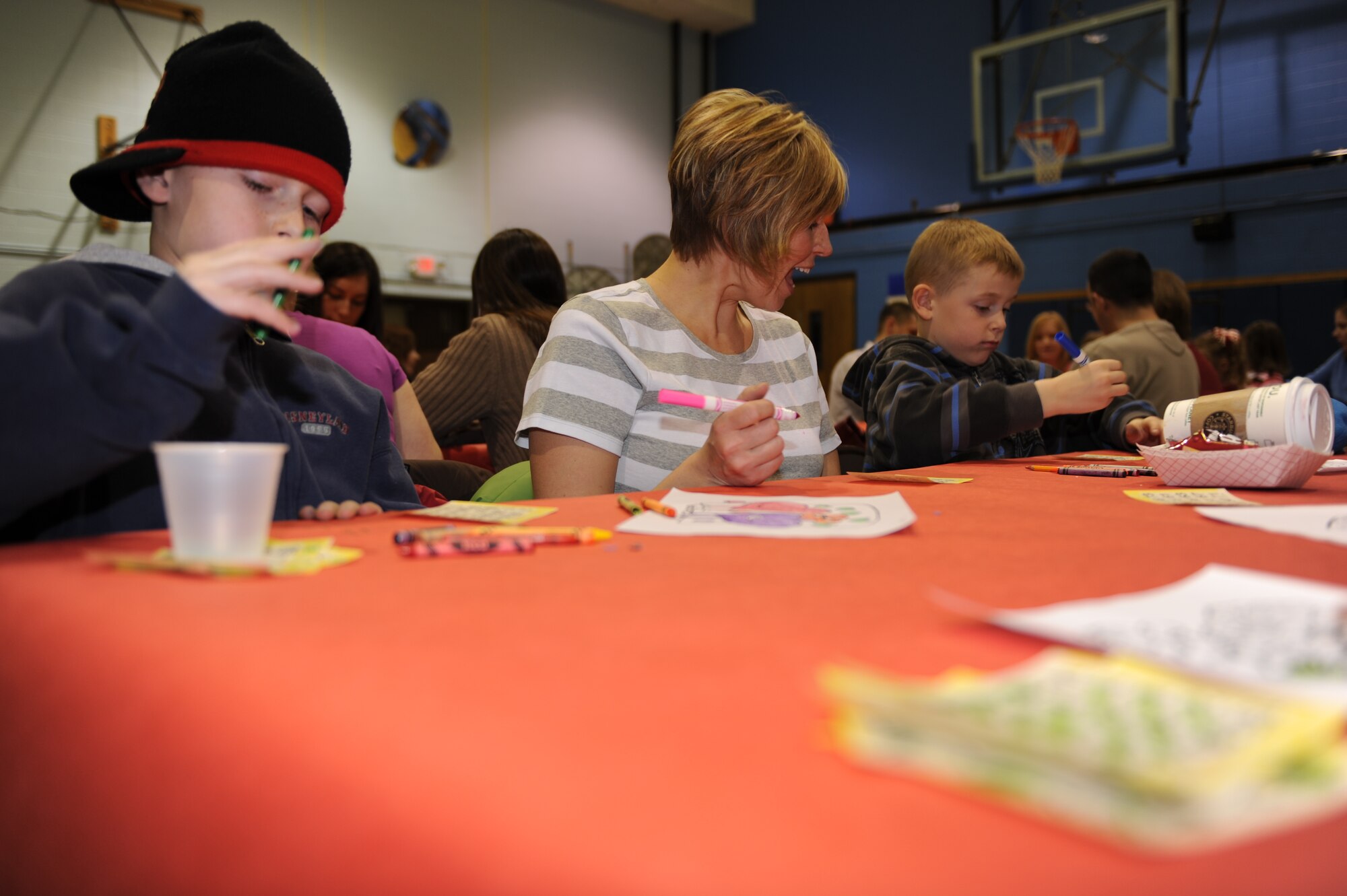 Gordie Straker, left, son of Tech. Sgt. Eric Straker, 28th Aircraft Maintenance Squadron weapons expediter currently deployed, plays bingo with his mother, Kelly, and brother, Toby, during Sweetheart Bingo on Feb 5. The Airman and Family Readiness Center sponsored this event for family members of Airmen deployed or on remote assignments. The mission of the Ellsworth AFRC is to provide versatile and responsive foundations, which  build readiness, retention and resiliency and lead to personal effectiveness. (U.S. Air Force photo/Master Sgt. Loren J. Bonser)