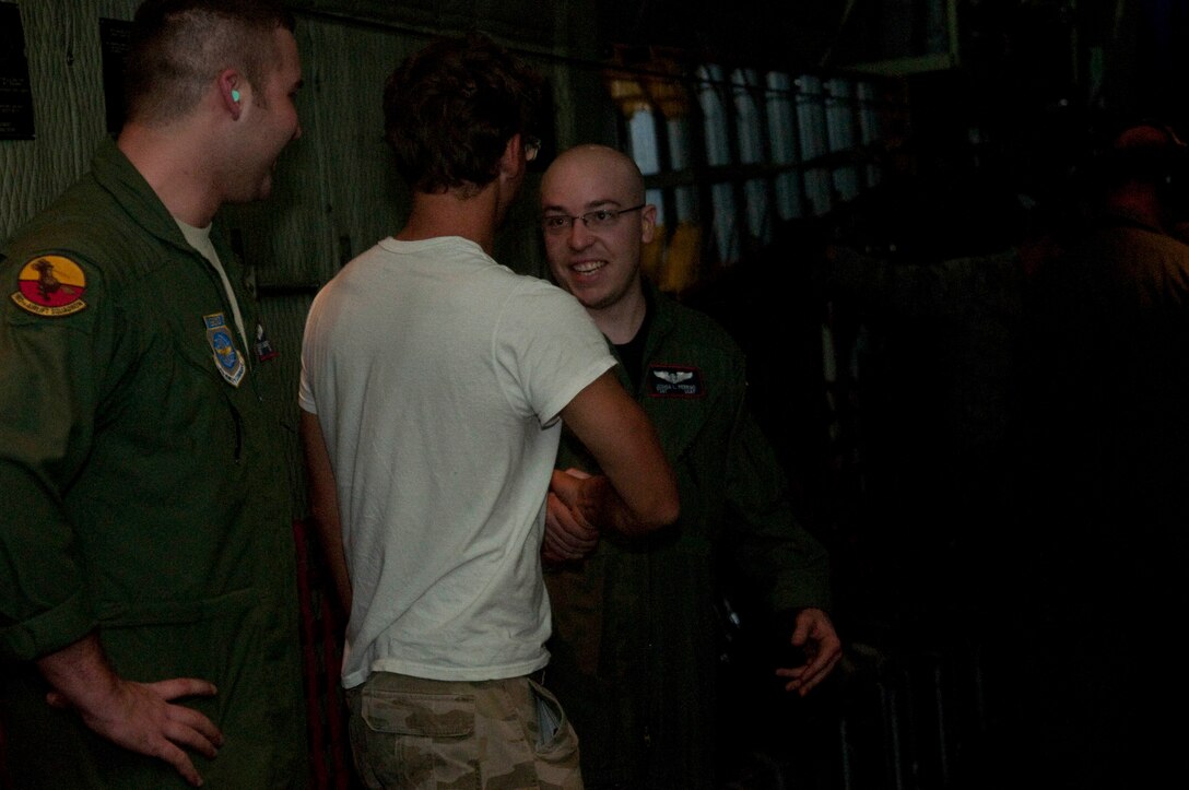 Tech. Sgt. Joshua Perrigo, 139th Airlift Wing, Mo. Air National Guard,  shakes a volunteers hand as Tech. Sgt. Tyler Lingerfelt, 139th AW, looks on February 6, 2010. The two load masters assist the volunteers on a  C-130, before they are flown home home after aiding relief efforts for more than two weeks in Haiti on February 6, 2010. (U.S. Air Force photo by Master Sgt. Shannon Bond/Released)