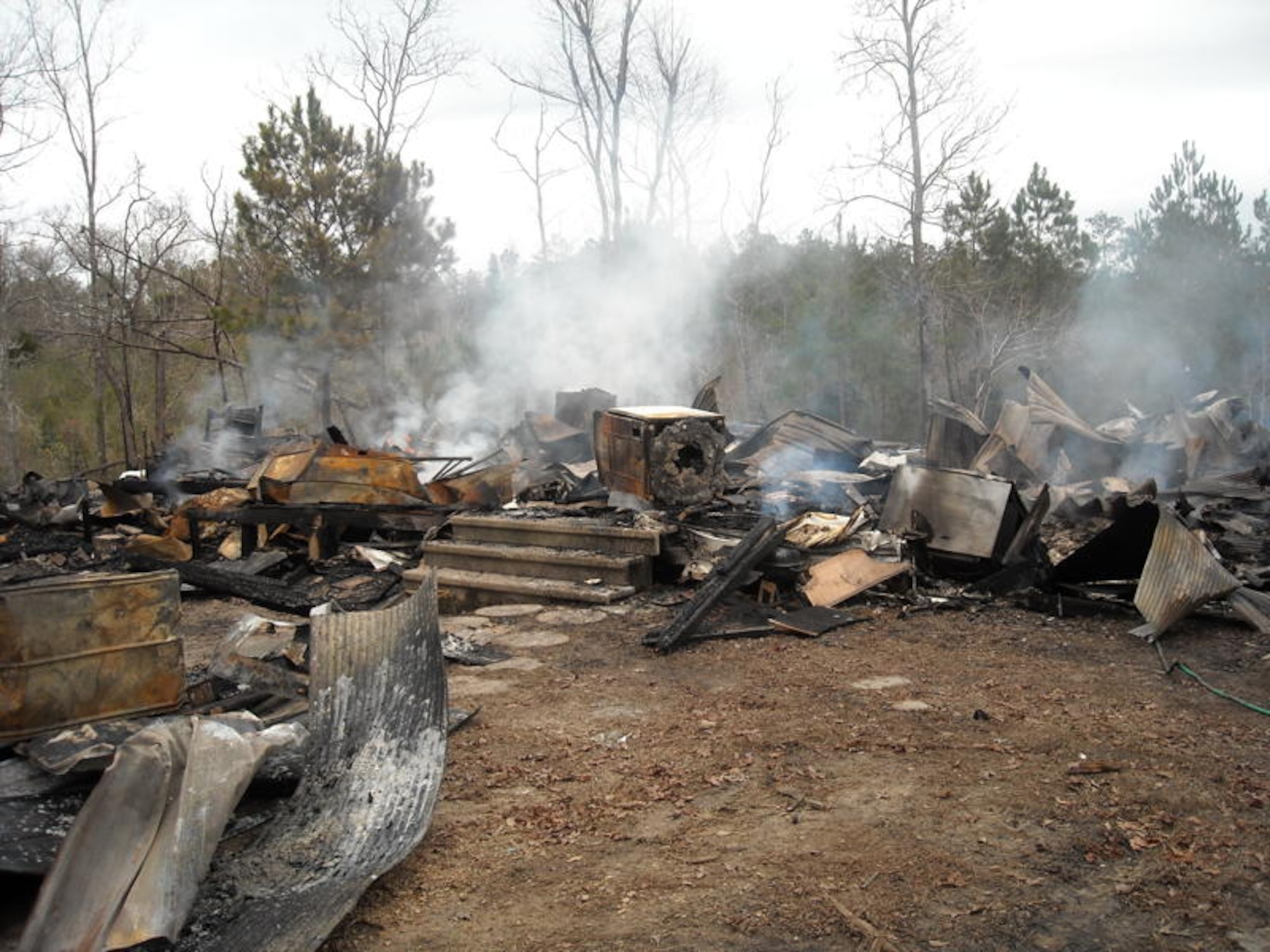 FORT EUSTIS, Va. -- The remains of the Lindsey home smolder after firefighters extinguished the fire Dec. 26, 2009. The lives of a pregnant mother and child were saved when Private Lester braved the heat and smoke inhalation to save them. (U.S. Army photo/Tetaun Moffett)