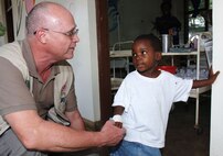 Col. (Dr.) James Swaby greets a young patient in a Kisumu clinic during a trip he took as part of an infectious disease field diagnostic development initiative Jan. 7, 2010, to Kenya, Africa. Doctor Swaby is the 59th Medical Wing Clinical Research Division chief from Lackland Air Force Base, Texas. (U.S. Air Force photo/Senior Airman Josie Kemp)