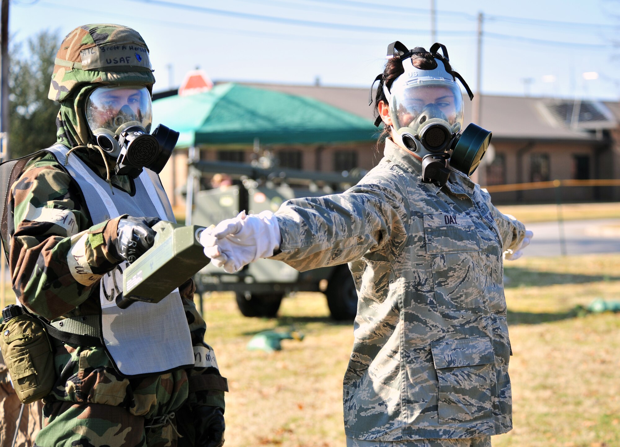 SHAW AIR FORCE BASE, S.C. -- Airman 1st Class Brett Hershberg (left), 20th Equipment Maintenance Squadron, simulates checking Senior Airman Nina Day, 20th Fighter Wing command post, for contamination during the phase II operational readiness exercise here Feb. 8. Airmenof the 20th Fighter Wing  practice decontamination in full mission-oriented protective posture, or MOPP, gear. Shaw performs routine exercises throughout the year to ensure Airmen are ready for deployments. (U.S. Air Force photo/Airman 1st Class Amber E. N. Jacobs)