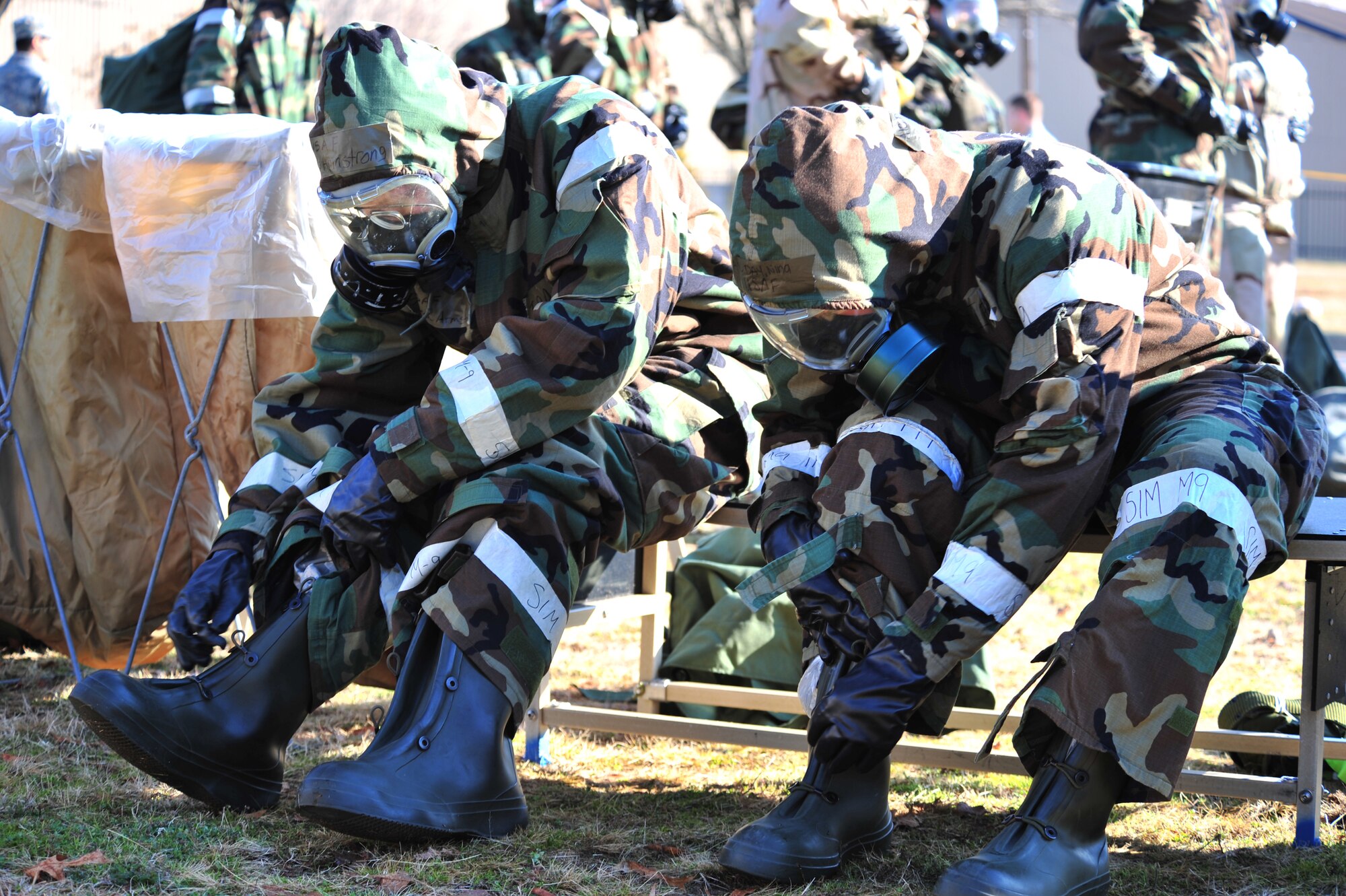 SHAW AIR FORCE BASE, S.C. -- Staff Sgt. Gena Armstrong (left) and Senior Airman Nina Day , 20th Fighter Wing Airmen, remove their protective overboots during the phase II operational readiness exercise here Feb. 8. Airmen of the 20th Fighter Wing prepare for the exercise by practicing decontamination in full mission-oriented protective posture, or MOPP, gear. Shaw performs routine exercises throughout the year to ensure Airmen are ready for deployments. (U.S. Air Force photo/Airman 1st Class Amber E. N. Jacobs)