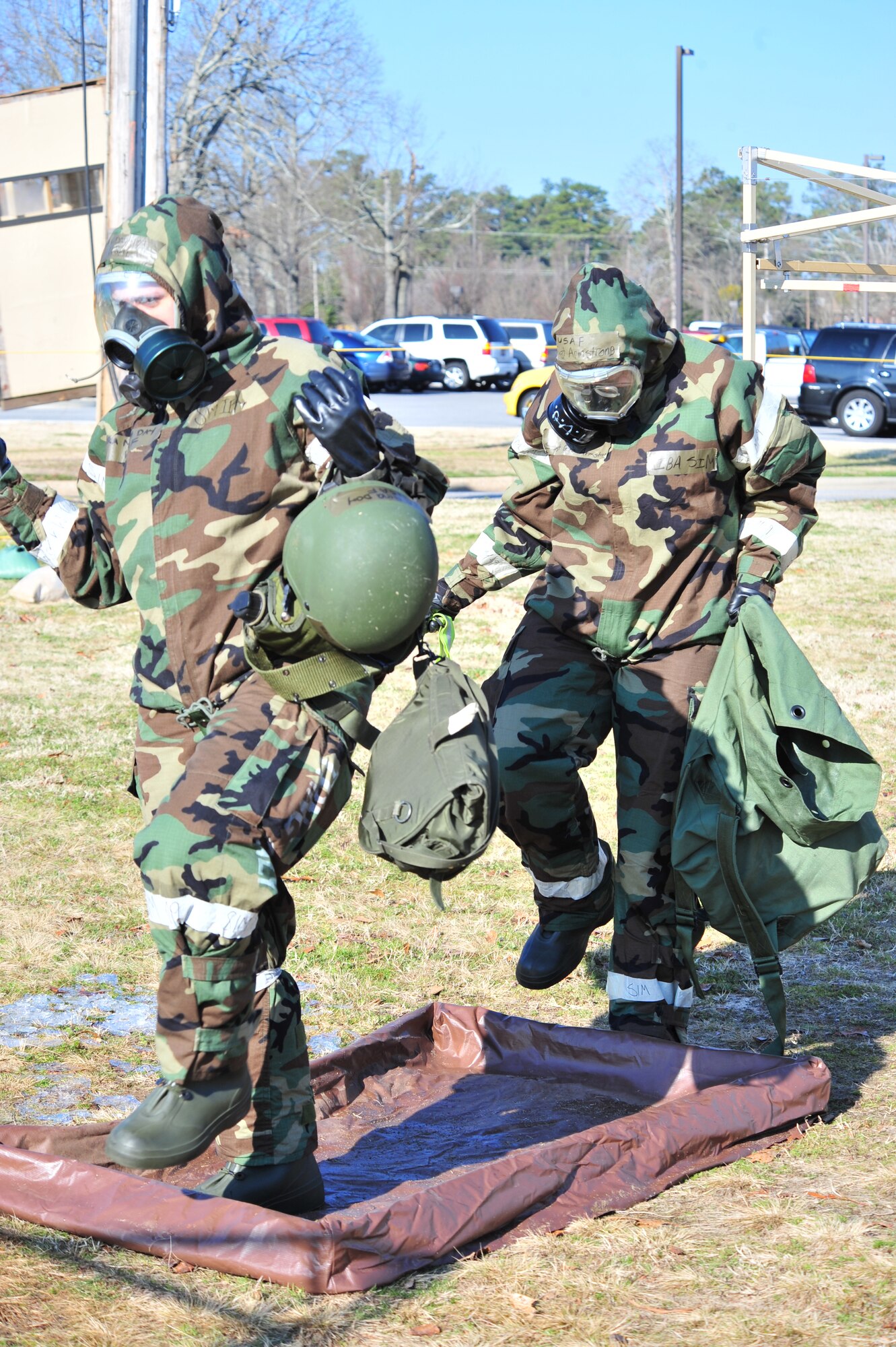 SHAW AIR FORCE BASE, S.C. -- Senior Airman Nina Day (left) and Staff Sgt. Gena Armstrong, 20th Fighter Wing Airmen, simulate washing off their boots during the phase II operational readiness exercise here Feb. 8. Airmen of the 20th Fighter Wing prepare for the exercise by practicing decontamination in full mission-oriented protective posture, or MOPP, gear. Shaw performs routine exercises throughout the year to ensure Airmen are ready for deployments. (U.S. Air Force photo/Airman 1st Class Amber E. N. Jacobs)