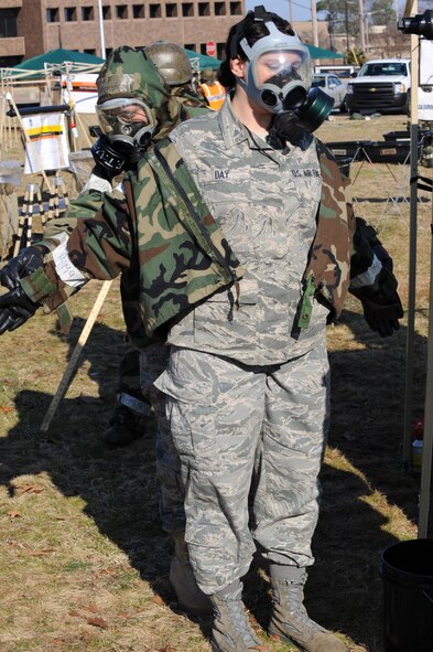 SHAW AIR FORCE BASE, S.C. -- Senior Airman Nina Day, 20th Fighter Wing finance technician, gets help removing her protective jacket after being decontaminated during a phase II operational readiness exercise Feb. 8. Shaw performs these exercises to ensure Airmen remain ready and fit for deployment. (U.S. Air Force photo/Airman 1st Class Neil D. Warner)