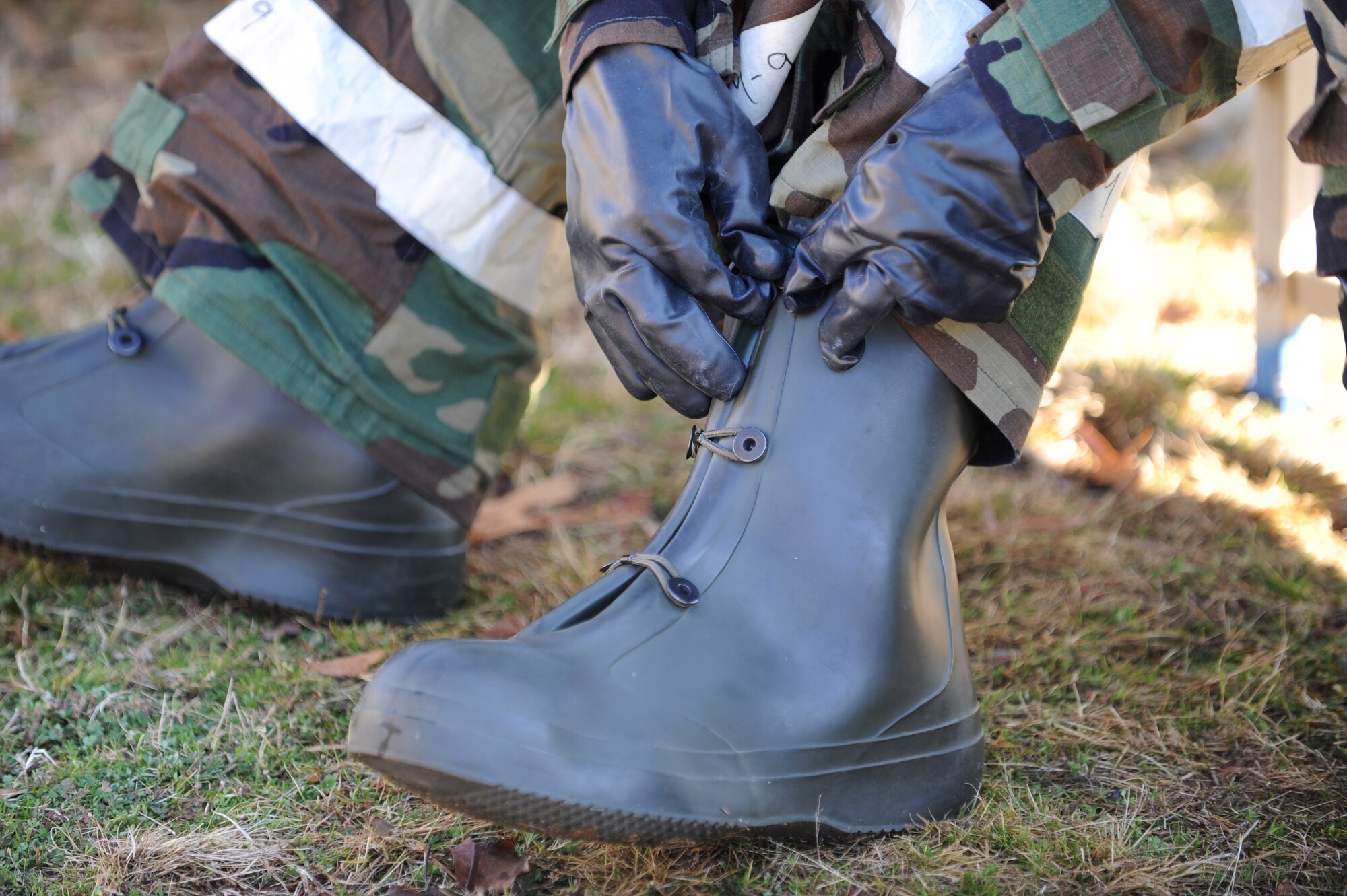 SHAW AIR FORCE BASE, S.C. -- Staff Sgt. Gena Armstrong, 20th Fighter Wing Public Affairs broadcaster, removes her protective boots during a phase II operational readiness exercise Feb. 8. Shaw performs these exercises to ensure Airmen  remain ready and fit for deployment. (U.S. Air Force photo/Airman 1st Class Neil D. Warner)