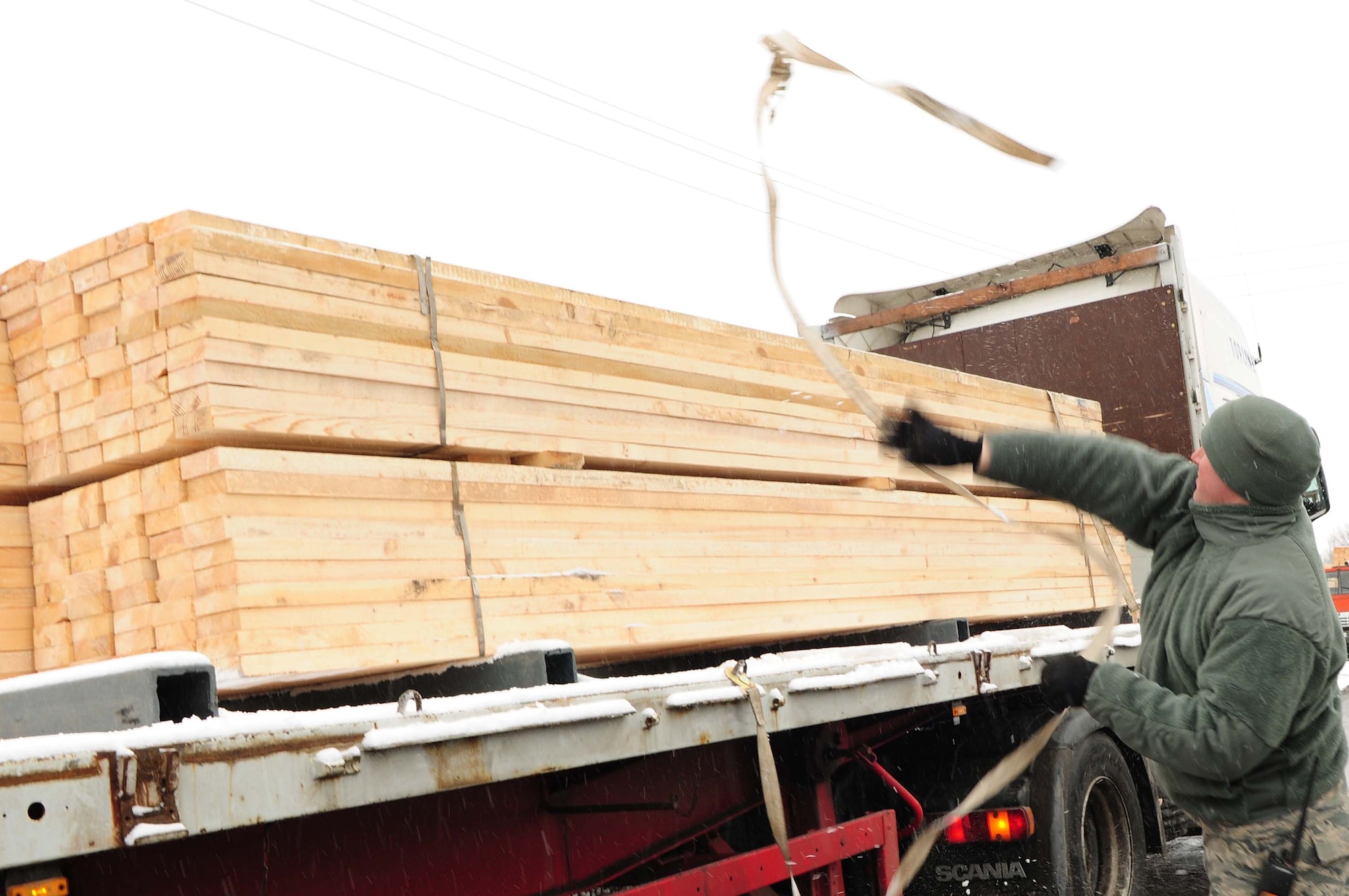 A member of the 376th Expeditionary Civil Engineer Squadron prepares a local Kyrgyz lumber supplier's entire stock of wood for unloading onto the Transit Center at Manas, Kyrgyzstan, Feb 3, 2010. The 376th Expeditionary Contracting Squadron here purchased more than 13,000 pieces of lumber to ship to Afghanistan for base buildup. This massive transfer will boost the local economy and help coalition forces downrange. The project was made possible through the collaborative efforts of contracting, security forces, civil engineers, aerial porters, logistics, and many other support agencies on the Transit Center. Look for an upcoming story on the start-to-finish process. (U.S. Air Force photo/Senior Airman Nichelle Anderson/released)