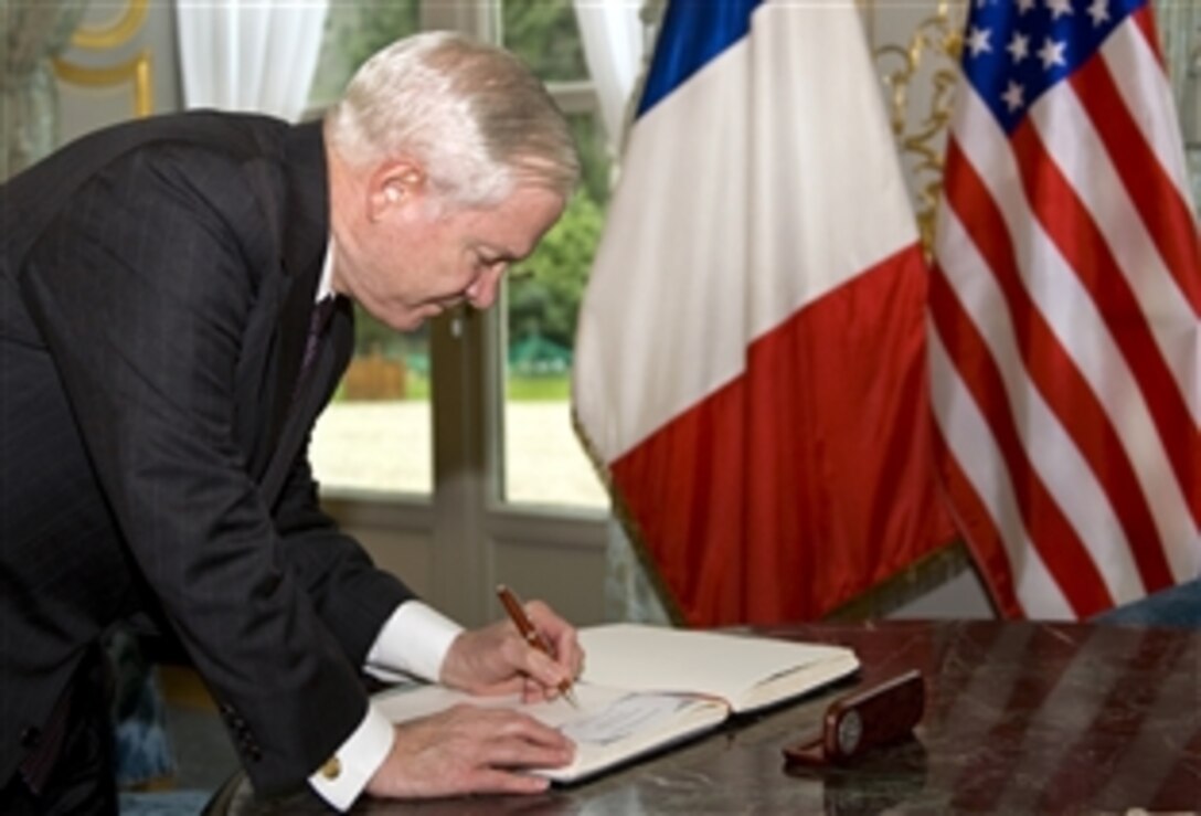 U.S. Defense Secretary Robert M. Gates signs the guest book at the French Defense Ministry in Paris, Feb. 8, 2010.