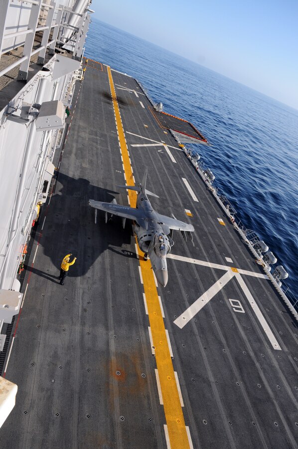 Capt. Michael Cassidy, Marine Attack Squadron 311 pilot, taxis on the flight deck of the USS Peleliu as a Navy aircraft handler directs him during the squadron's aircraft carrier qualifications Feb. 8, 2010. Approximately 10 pilots and 15 support and maintenance personnel participated in the exercise. The squadron practiced Harrier operations aboard the aircraft carrier from Feb. 8-11, including night flights, in preparation for the squadron’s upcoming deployment aboard the Peleliu with the 15th Marine Expeditionary in May.