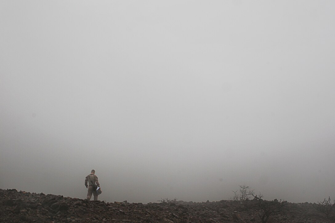 A Marine from 81mm mortar platoon, Weapons Company, Battalion Landing Team 2/4, 11th Marine Expeditionary Unit, walks to his platoon, waiting for the fog to lift so that his fellow Marines can begin firing mortars here Feb 8. Marines from the platoon conducted mortar live-fire shoots and coordinated supporting fires with fixed and rotary wing aircraft from Marine Medium Helicopter Squadron 166 (Reinforced).