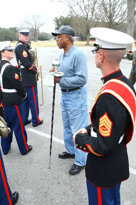 The first African American drum major, retired Gunnery Sgt. James Richardson, takes a moment to speak the troops of the 2nd Marine Division Band Feb. 9 in the Paradise Point Golf Course parking lot. After Gunnery Sgt. David Wilson, drum major with 2nd MARDIVE band, offered his gloves and mace, Richardson was given the opportunity the lead a band once again.