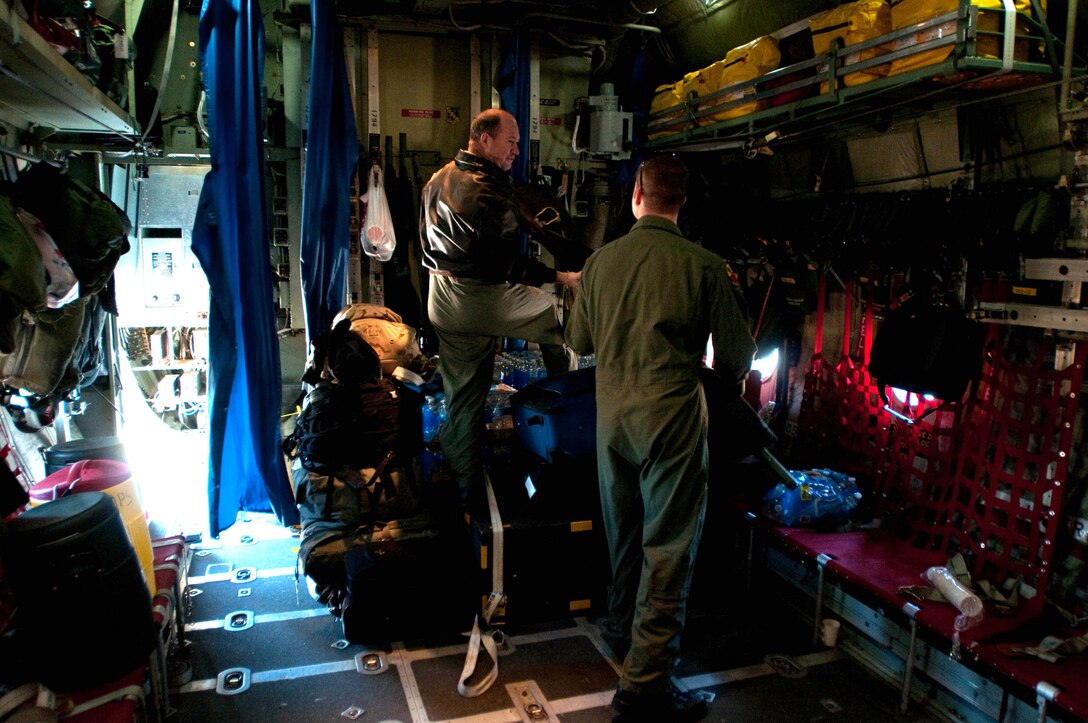 Senior Master Sgt. Wayne Ward looks back at Technical Sgt. Tyler Lingerfelt as they load a 139th Airlift Wing, Mo. Air National Guard, C-130 for a relief mission to Port-Au-Prince, Haiti on February 9, 2010. (U.S. Air Force photo by Master Sgt. Shannon Bond/Released)