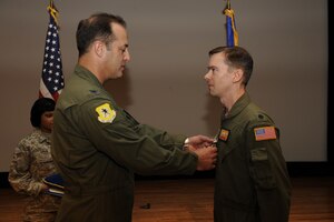 Col. Bob Holba presents Lt. Col. Christopher Mann with a Bronze Star Medal during a commanderÕs call at the base theater Jan. 29. Colonel Mann distinguished himself while serving as commander of the 816th Expeditionary Airlift Squadron, supporting ground and air operations while deployed to the Middle East from Jan. 1 to April 30, 2009. Under Colonel MannÕs leadership, the 816 EAS executed the single largest C-17A combat air delivery effort to date in the history of the Global War on Terrorism. In total, the squadronÕs operations accounted for 70 percent of all airland cargo and more than 95 percent of all air delivery cargo provided in support of three major areas of responsibility. Additionally, the squadron pioneered the expansion of the C-17AÕs combat role by conducting the first-ever C-17A leaflet air delivery over 14 insurgent-held strongholds in Afghanistan. The accomplishments are only a few among numerous achievements under Colonel MannÕs leadership. Colonel Holba is the 437th Operations Group commander, and Colonel Mann is the 16th Airlift Squadron commander. (U.S. Air Force photo/Staff Sgt. Eric Harris)