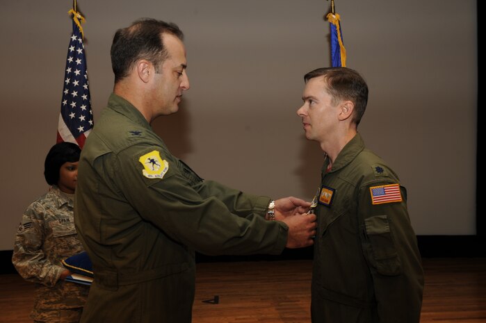 Col. Bob Holba presents Lt. Col. Christopher Mann with a Bronze Star Medal during a commanderÕs call at the base theater Jan. 29. Colonel Mann distinguished himself while serving as commander of the 816th Expeditionary Airlift Squadron, supporting ground and air operations while deployed to the Middle East from Jan. 1 to April 30, 2009. Under Colonel MannÕs leadership, the 816 EAS executed the single largest C-17A combat air delivery effort to date in the history of the Global War on Terrorism. In total, the squadronÕs operations accounted for 70 percent of all airland cargo and more than 95 percent of all air delivery cargo provided in support of three major areas of responsibility. Additionally, the squadron pioneered the expansion of the C-17AÕs combat role by conducting the first-ever C-17A leaflet air delivery over 14 insurgent-held strongholds in Afghanistan. The accomplishments are only a few among numerous achievements under Colonel MannÕs leadership. Colonel Holba is the 437th Operations Group commander, and Colonel Mann is the 16th Airlift Squadron commander. (U.S. Air Force photo/Staff Sgt. Eric Harris)