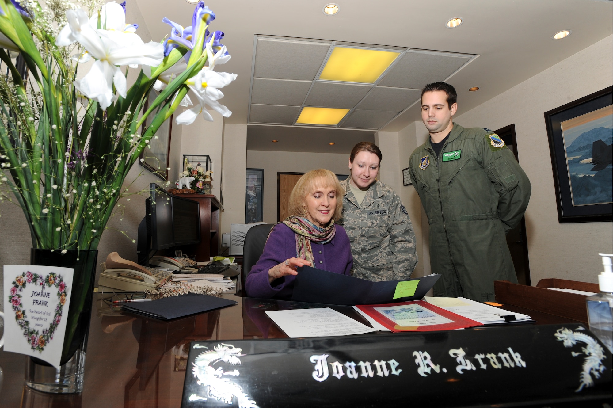 ELMENDORF AIR FORCE BASE, Alaska -- Joanne Frank, the 3rd Wing Commander's secretary, goes over a travel voucher with Staff Sgt. Connie Abolos, 3rd Wing Command Chief executive, and Capt. Levi Rains, acting 3rd Wing executive officer. (Air Force photo by Staff Sgt. Joshua Garcia) 