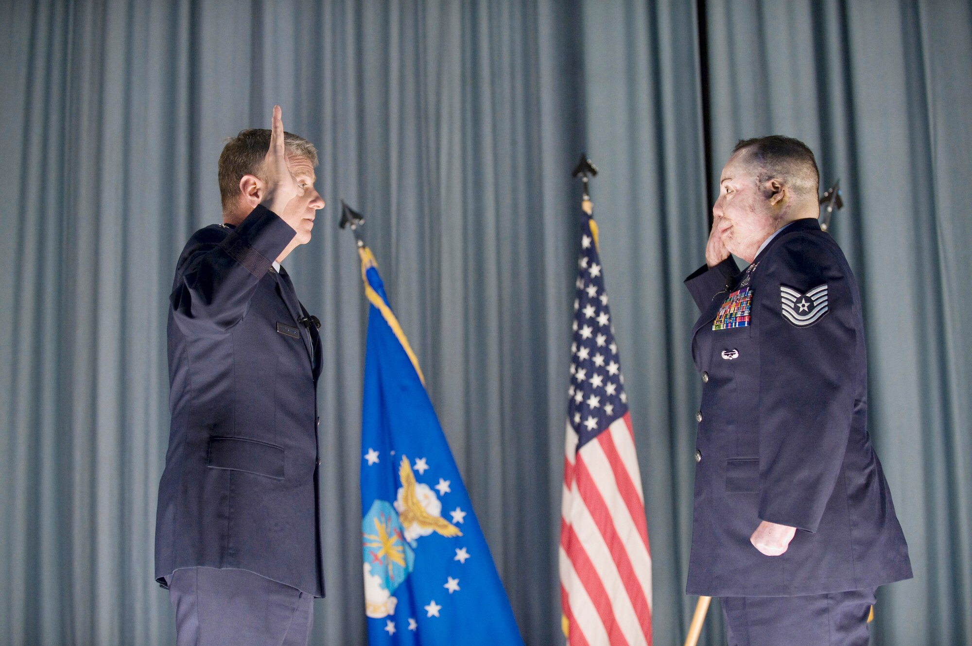 Maj. Gen. Anthony Przybyslawski, vice commander of Air Education and Training Command, administers the oath of enlistment Feb. 8 to Tech. Sgt. Israel Del Toro in the nearly packed base theater at Randolph Air Force Base, Texas. Sergeant Del Toro suffered burns to more than 80 percent of his body after his vehicle was struck by an improvised explosive device in Afghanistan. (U.S. Air Force photo/Steve Thurow)