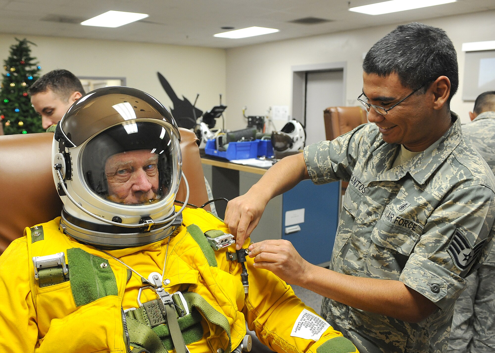 Staff Sgt. Ryan Santos with the 9th Physiology Support Squadron fits Mr. Oliver "Ollie" Crawford into a pressure suite in prepartion for his high-flight in the U-2 Dragon Lady. In December 2009, Mr. Crawford was the oldest person to recieve a high-flight in the U-2. (U.S. Air Force Photo/ John Schwab)