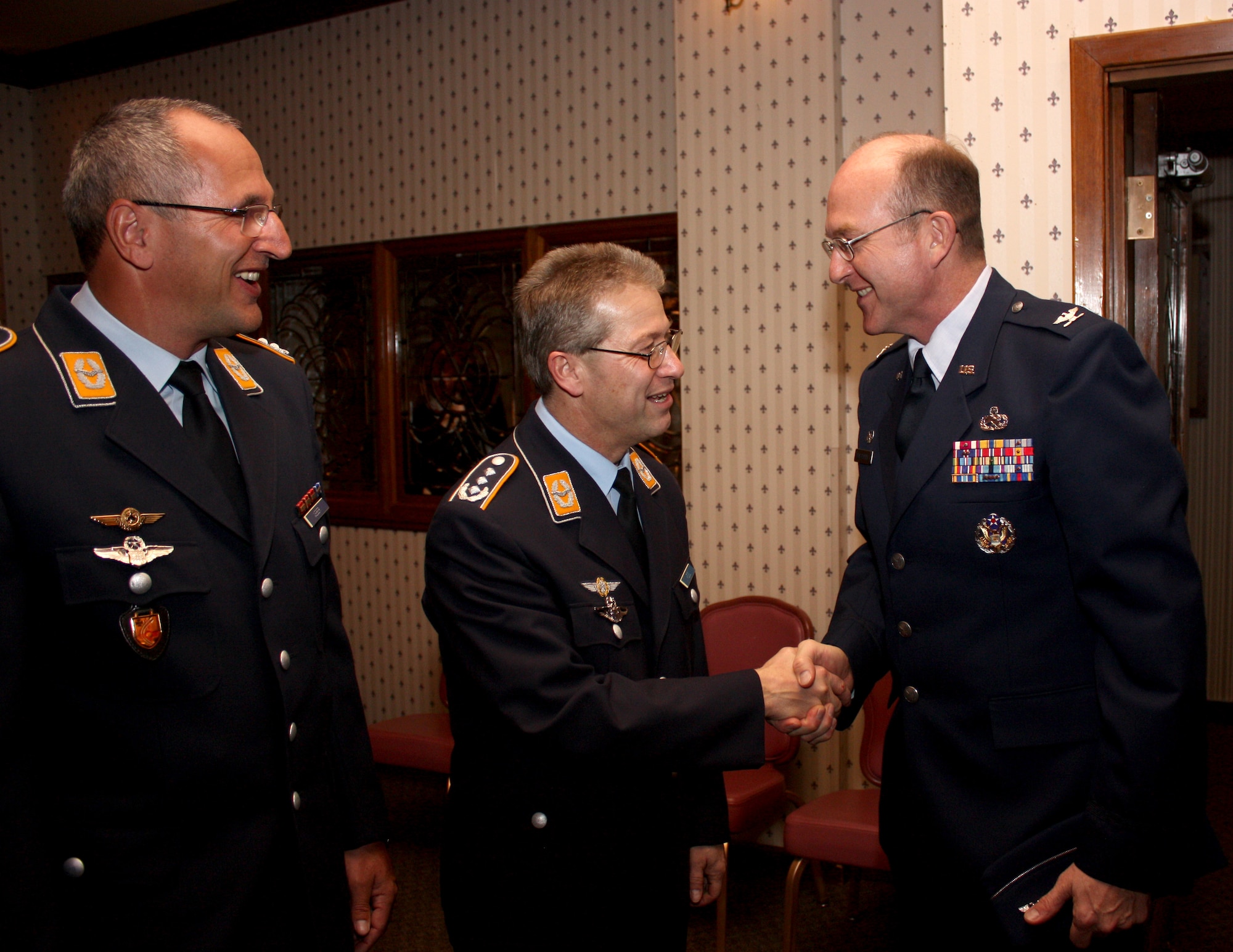 HOLLOMAN AIR FORCE BASE, N.M. -- Col. Frank Kiesel, commander of the German Air Force Flying Training Center, and Lt. Col. Hans Weber, GAF FTC vice commander, greet Col. Donald Van Patten, 49th Maintenance Group commander, during a New Year's reception at the Raptor?s Nest, Feb. 2. During the event, the GAF FTC commander reflected on the past two years of flying training and training support at Holloman. (German air force photo by Chief Master Sgt. Robert Meints)