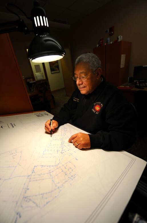OFFUTT AIR FORCE BASE, Neb.- Santiago Olmeda-Pinero, assistant fire chief with the 55th Civil Engineering Squadron Fire Department, reviews water line grid blueprints in his office, Feb. 5.  The water grid map is a useful tool in ensuring that new construction or remodeling of base facilities meet required building codes for sprinkler systems and other facets of construction, such as how water enters and leaves a building. U.S. Air Force photo by Josh Plueger
