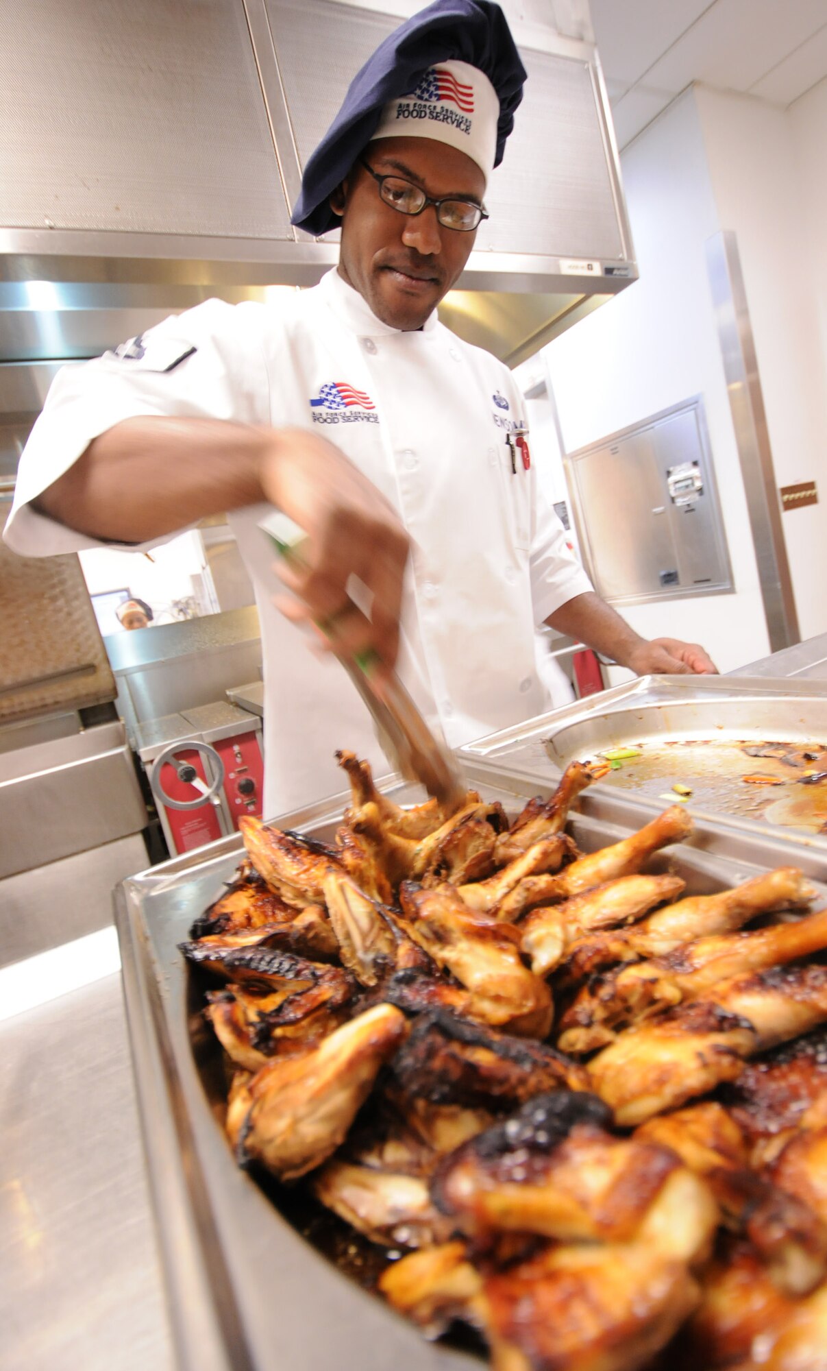 Staff Sgt. Marcus Newsome, 96th Force Support Squadron, prepares some chicken wings prior to lunch at Eglin's "The Breeze" dining facility, Feb. 9.  The "Breeze" serves approximately 580 personnel at lunch and 1,500 throughout the day between breakfast and dinner.  (U.S. Air Force photo/Airman 1st Class Anthony Jennings.)