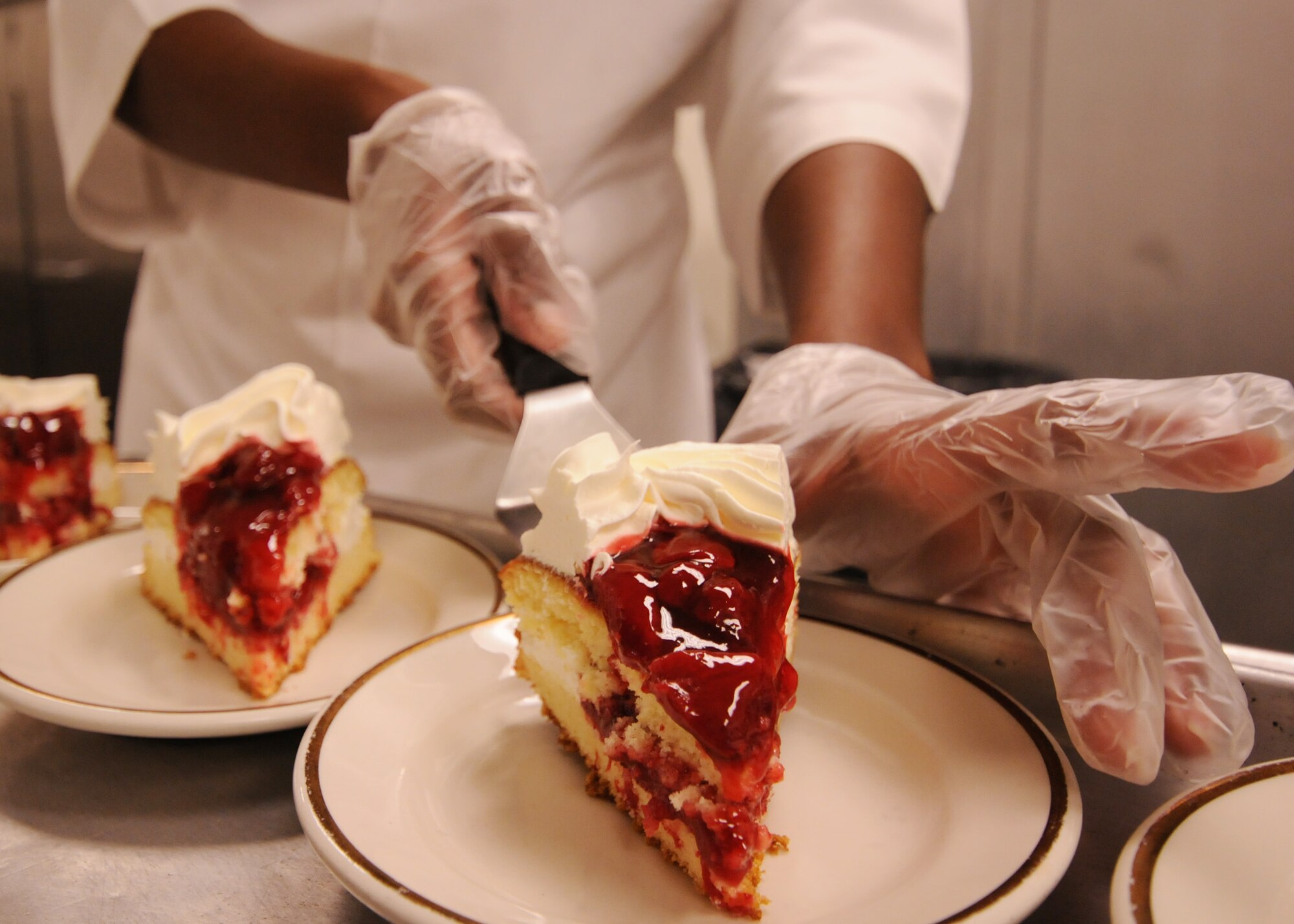 Slices of strawberry shortcake are delicately placed on plates prior to lunch at Eglin's Gulf Breeze dining facility.  The "Breeze" serves approximately 580 personnel at lunch and 1,500 throughout the day between breakfast and dinner.  (U.S. Air Force photo/Airman 1st Class Anthony Jennings.)