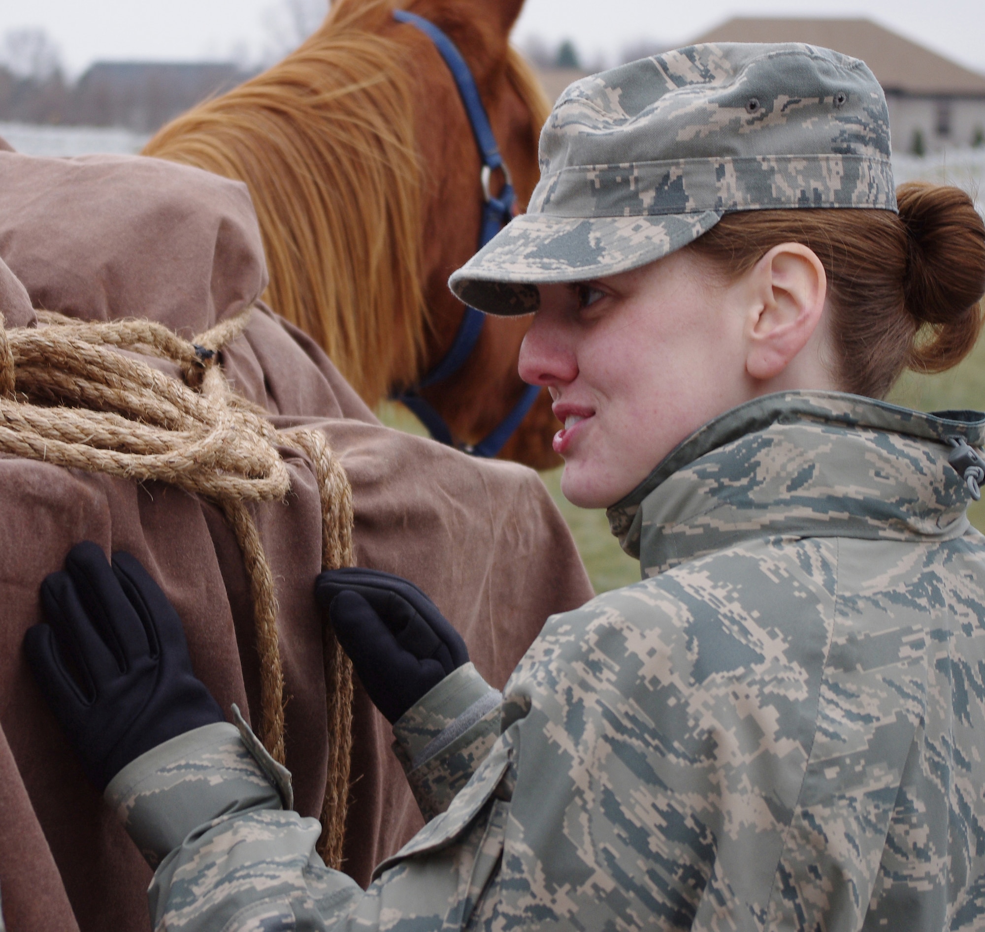 CAMP ATTERBURY, Ind. -- Air Force Tech. Sgt. Carolyn McIlvaine, deployed from Eglin Air Force Base, Fla., loads a pack horse during a training event near here. Members of Provincial Reconstruction Team Panjshir learned to ride and load horses as part of their pre-deployment training. McIlvaine and other members of PRT Panjshir, who are deployed from various Air Force bases and Army posts, are attending the training here in preparation to move forward to the Panjshir Province in Afghanistan. Once in Afghanistan, the team will spend almost a year promoting local governance in the region. (U.S. Air Force photo/Army Sgt. Matthew Ryan)