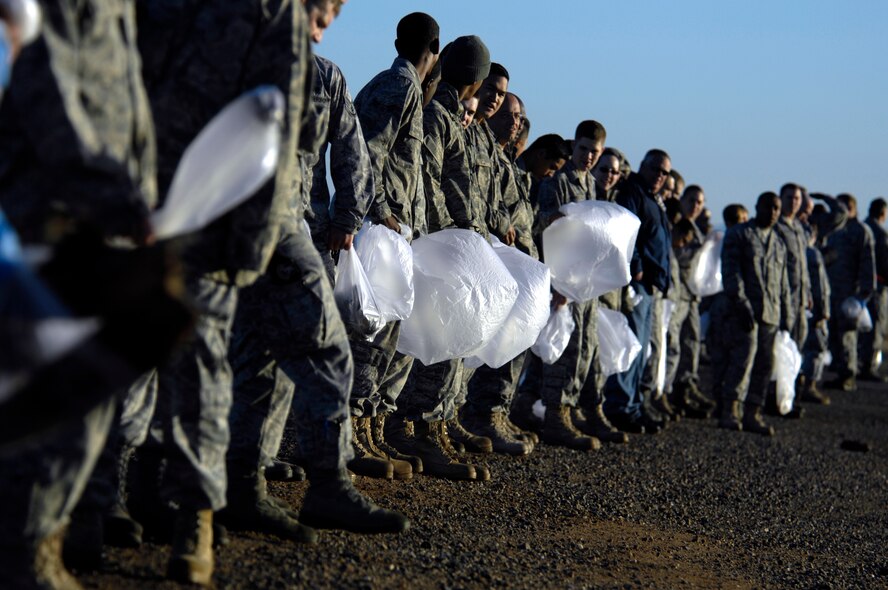 Members of the 56th Fighter Wing walk and pick up pieces of foriegn object debris during the Wing FOD walk, Feb. 08, 2010, Luke Air Force Base, Ariz. (U.S. Air Force Photo by Staff Sgt. Jason Colbert)