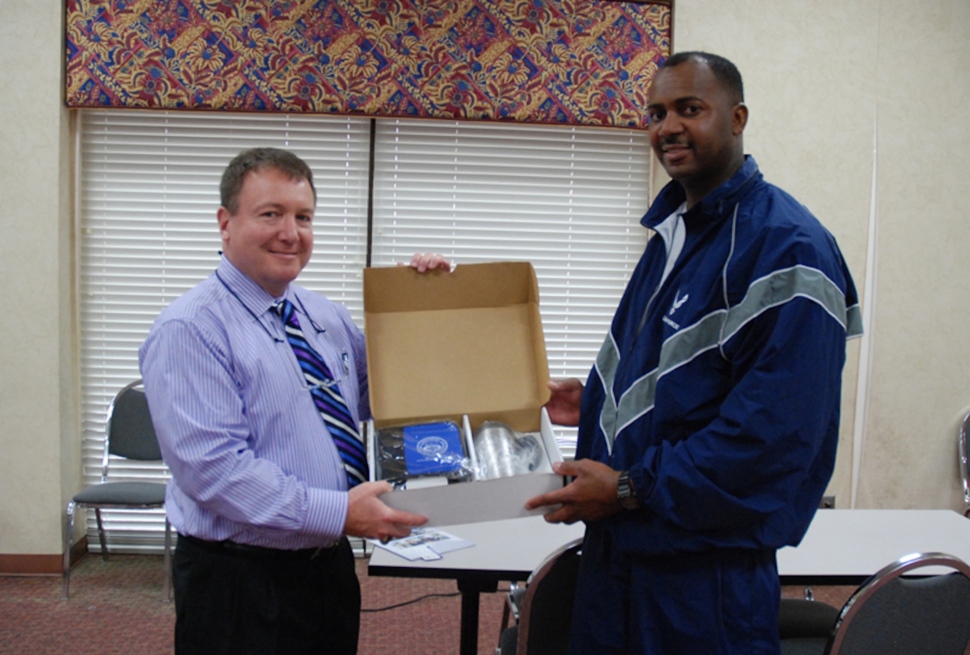 Chief Master Sgt. (Ret.) David Scholch presents Master Sgt. Mitch Daniels with a gift set from a drawing held by Columbia Southern University at the 2010 Education fair at Verhulst Hall here Feb. 6-7. Chief Scholch is and educational representative for CSU. (U.S. Air Force photo/Tech. Sgt. James Branch)