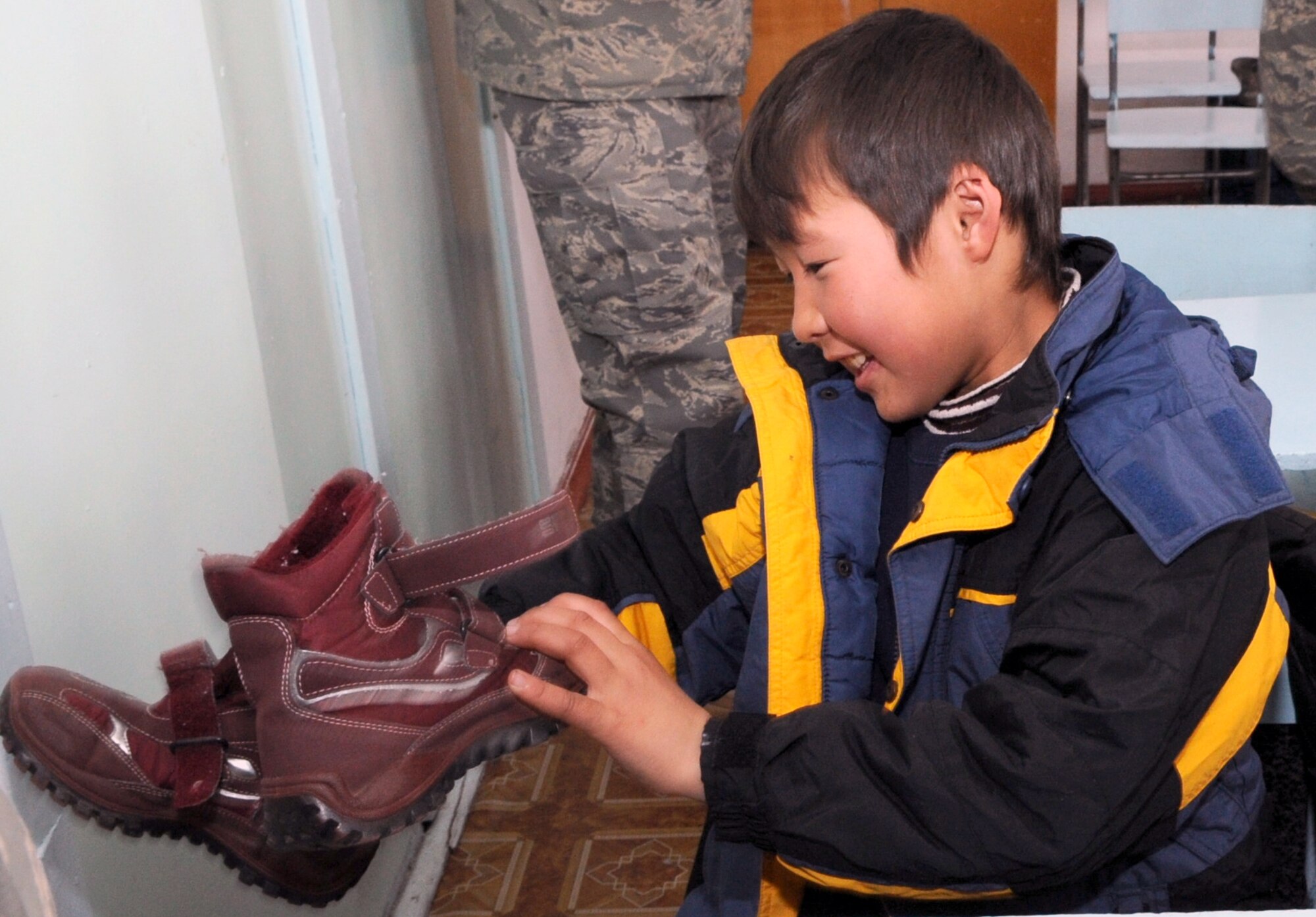 An elementary school boy from Grozd School in Grozd Village, Kyrgyzstan, is glad to receive warm boots from Airmen from the Transit Center at Manas Feb. 9, 2010. (U.S. Air Force photo/ Senior Airman Nichelle Anderson /released)