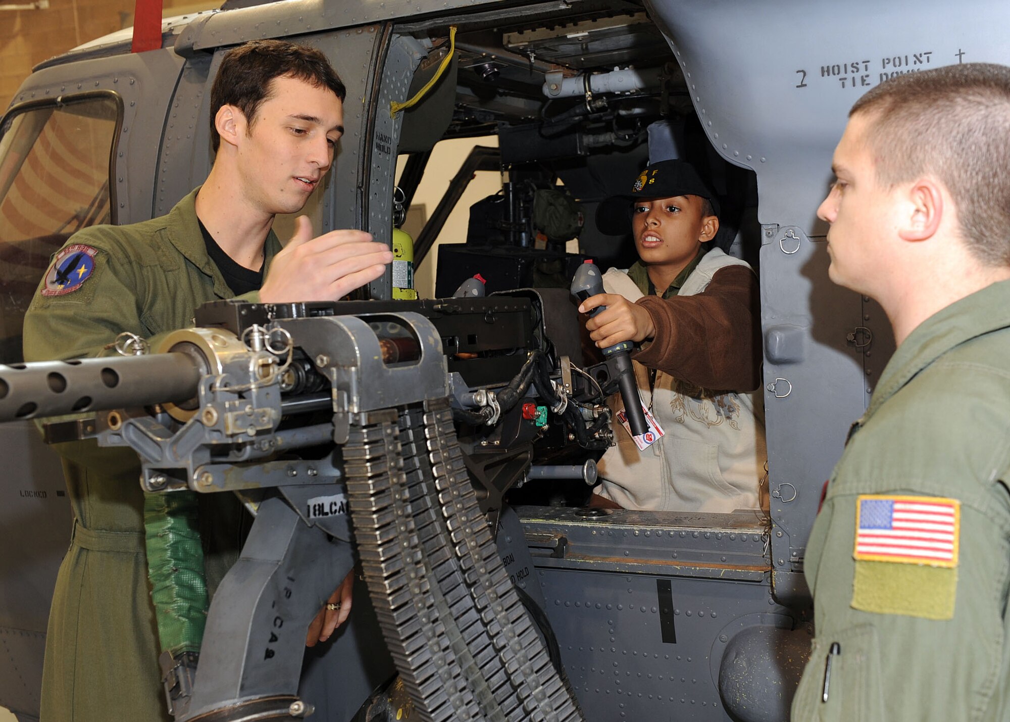 Staff Sgts. Christopher Hendrix and Joshua Reid, 55th Rescue Squadron, show Markino Mctaggrait a .50-caliber machine gun on the side of an HH-66 Pave Hawk during the Pilot for a Day program here on Jan. 29. This program is designed for children with serious illnesses and helps them enjoy a day totally devoted to them and their interest in aviation. Markino had a chance to fly in an A-10 simulator, see the base's fire department, aircraft static displays and meet members of the U.S. Air Force. (U.S. Air Force/Staff Sgt. Jacqueline Romero)
