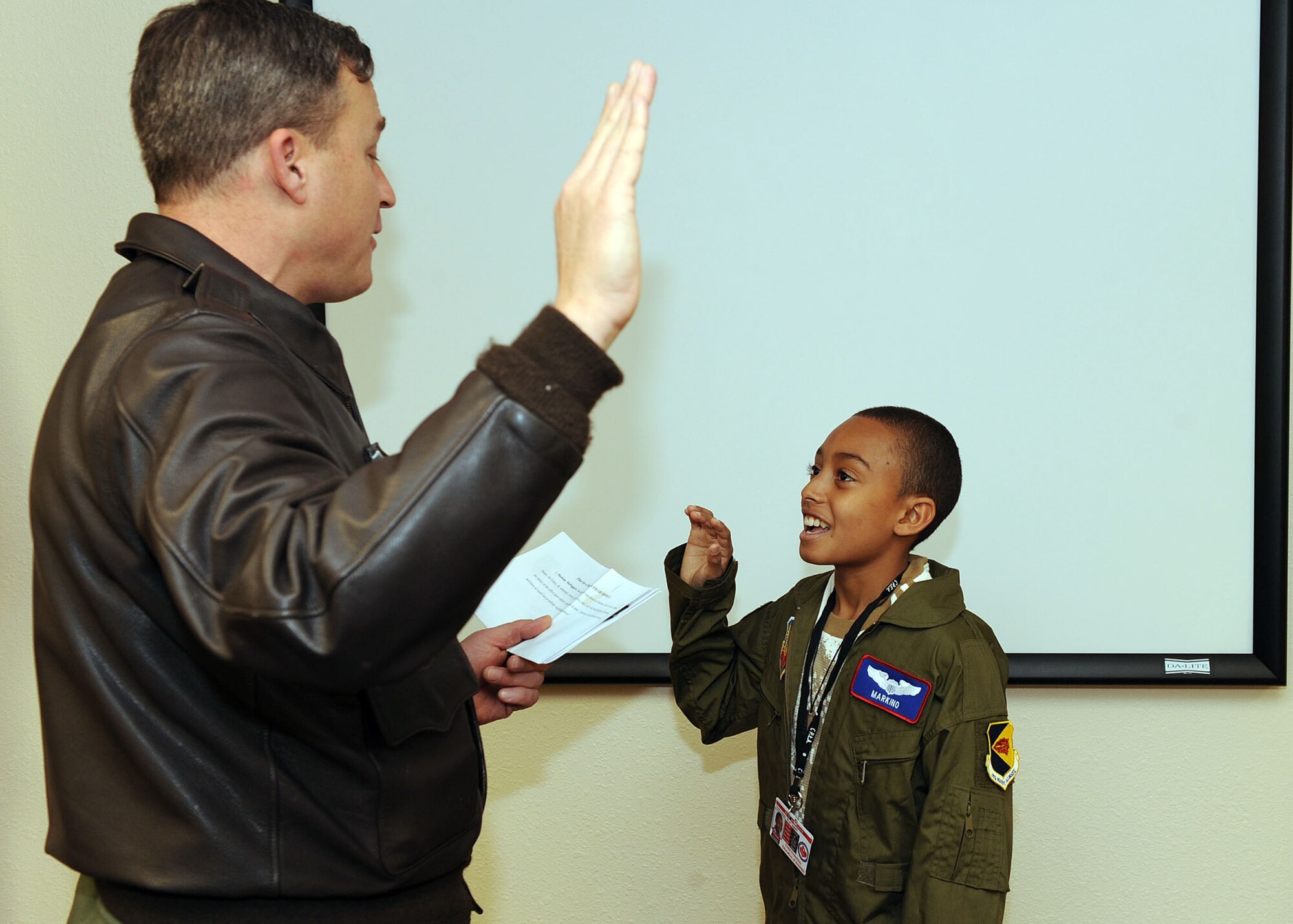 Col. Edward Kostenlnik, 355th Operations Group commander, administers an oath to 10-year-old Markino Mctaggrait during the Jan. 29 Pilot for a Day program here. This program is designed for children with serious illnesses and helps them enjoy a day totally devoted to them and their interest in aviation. Markino had a chance to fly in an A-10 simulator, see the base's fire department, aircraft static displays and meet
members of the U.S. Air Force.  (U.S. Air Force/Staff Sgt. Jacqueline Romero)
