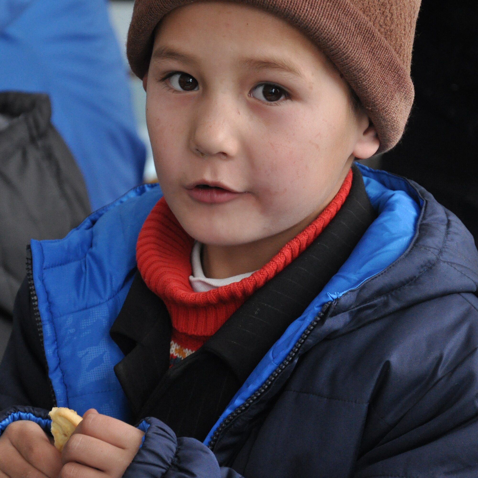 An elementary school boy from Grozd School in Grozd Village, Kyrgyzstan, is glad to receive warm clothing, snacks and other items from Airmen from the Transit Center at Manas Feb. 9, 2010. (U.S. Air Force photo/Staff Sgt. Carolyn Viss/released)