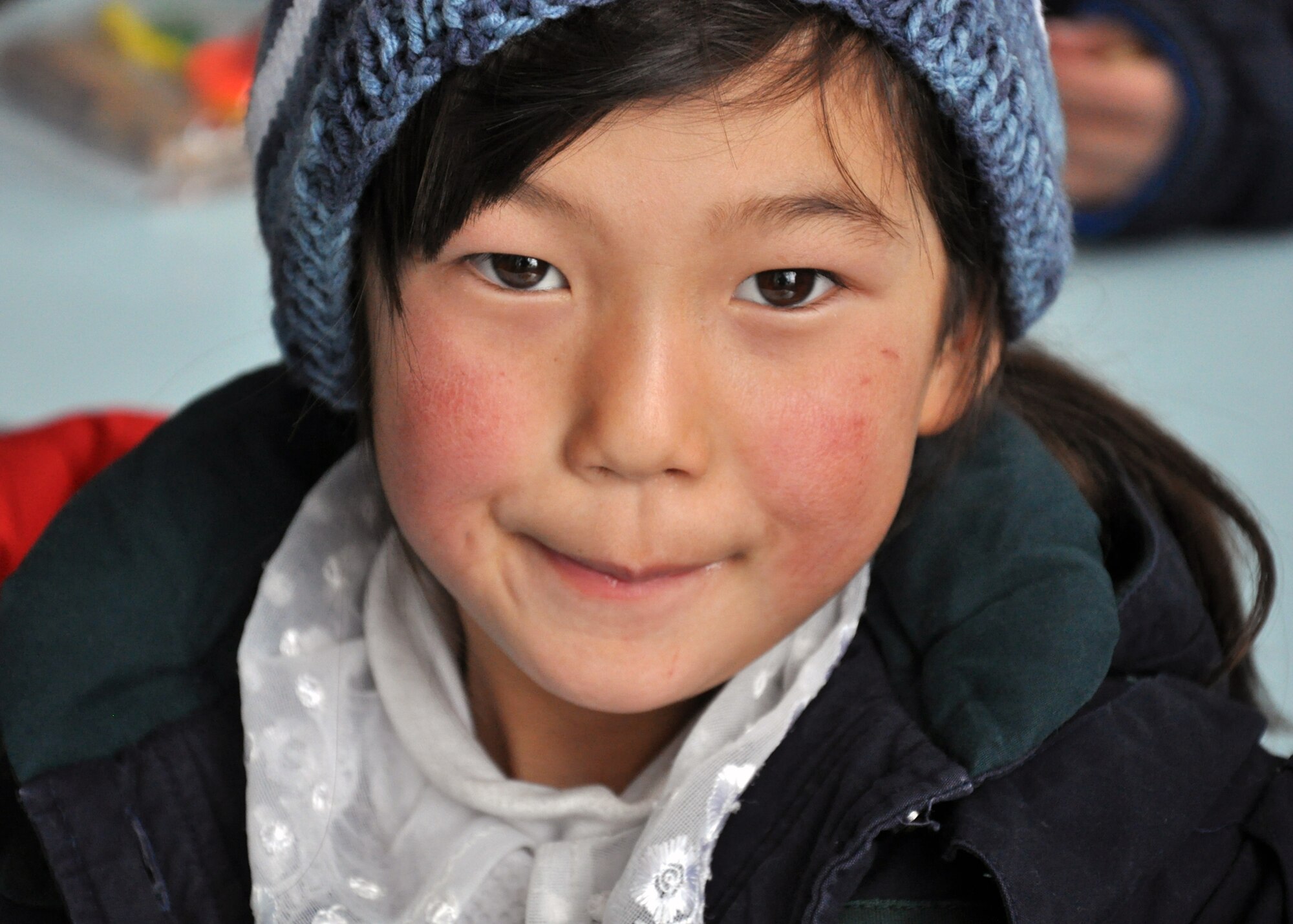 An elementary school girl from Grozd School in Grozd Village, Kyrgyzstan, is glad to receive warm clothing and other items from Airmen from the Transit Center at Manas Feb. 9, 2010. (U.S. Air Force photo/Staff Sgt. Carolyn Viss/released)