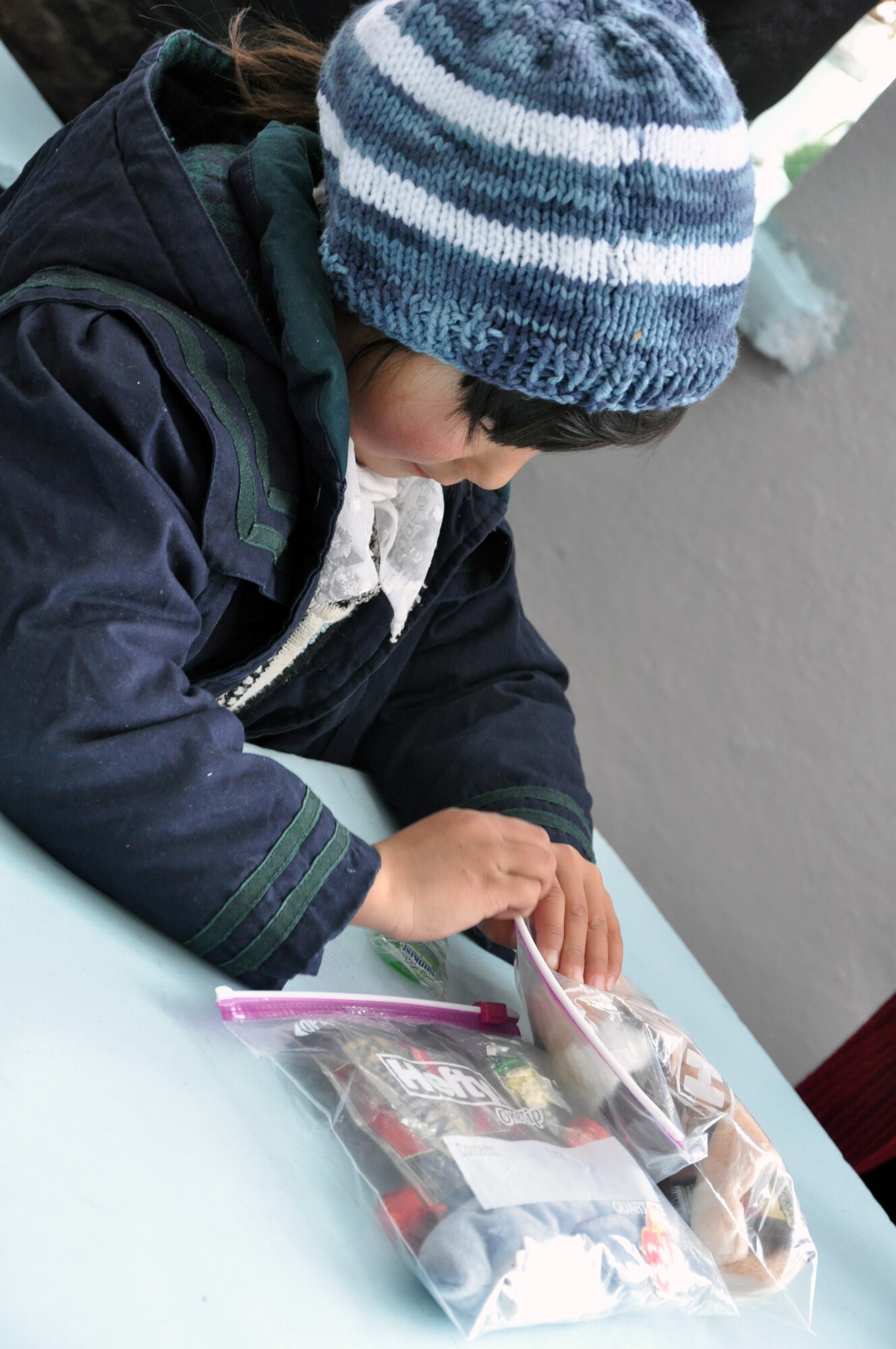 An elementary school girl from Grozd School in Grozd Village, Kyrgyzstan, examines the items she received from Airmen from the Transit Center at Manas Feb. 9, 2010. (U.S. Air Force photo/Staff Sgt. Carolyn Viss/released)