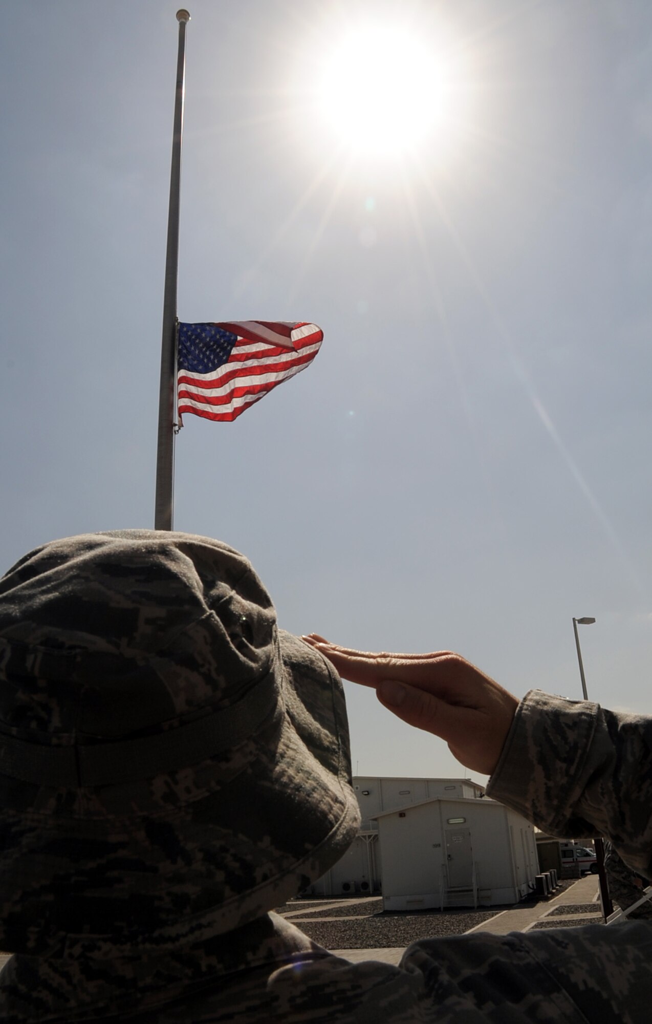 An Airman assigned to the 380th Air Expeditionary Wing at a non-disclosed base in Southwest Asia salutes the American flag Feb. 9, 2010, that is flying at half-mast in honor of U.S. Representive John Murtha of Pennsywho died on Feb. 8. Representative Murtha was a military veteran who earned the Bronze Star and two Purple Hearts during the Vietnam War. Military installations around the world flew the flag at half-mast Feb. 9 in honor of Representative Murtha by declaration from President Barack Obama. (U.S. Air Force Photo/Master Sgt. Scott T. Sturkol/Released)