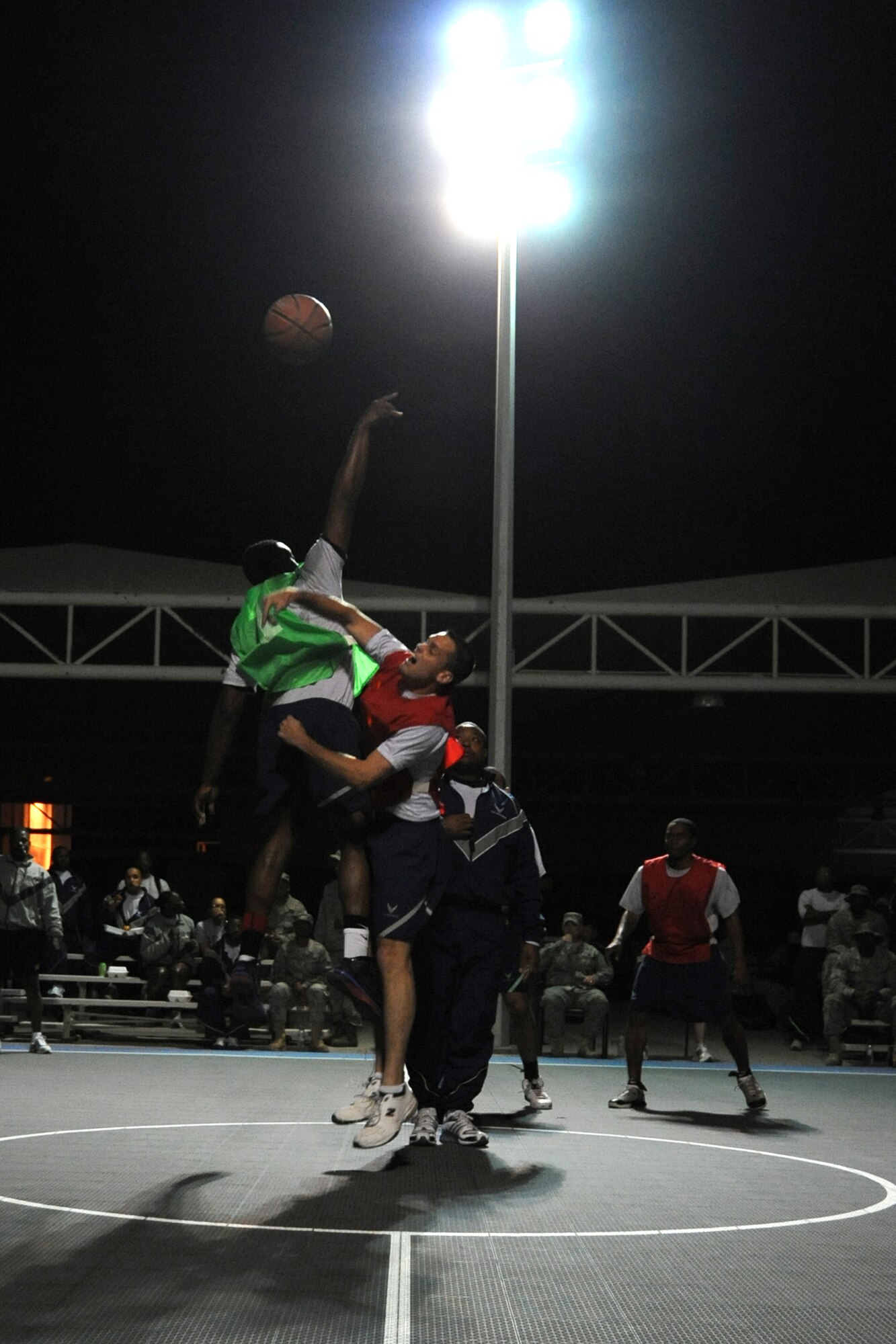 Members of the 380th Expenditionary Civil Engineer Squadron and 380th Expeditionary Security Forces Squadron go for the ball during tip-off during the intramural basketball championshiop game at undisclosed location in Southwest Asia on Feb. 5, 2010. ECES won the game 30 to 24.(U.S. Air Force photo/Senior Airman Jenifer H. Calhoun/Released)
