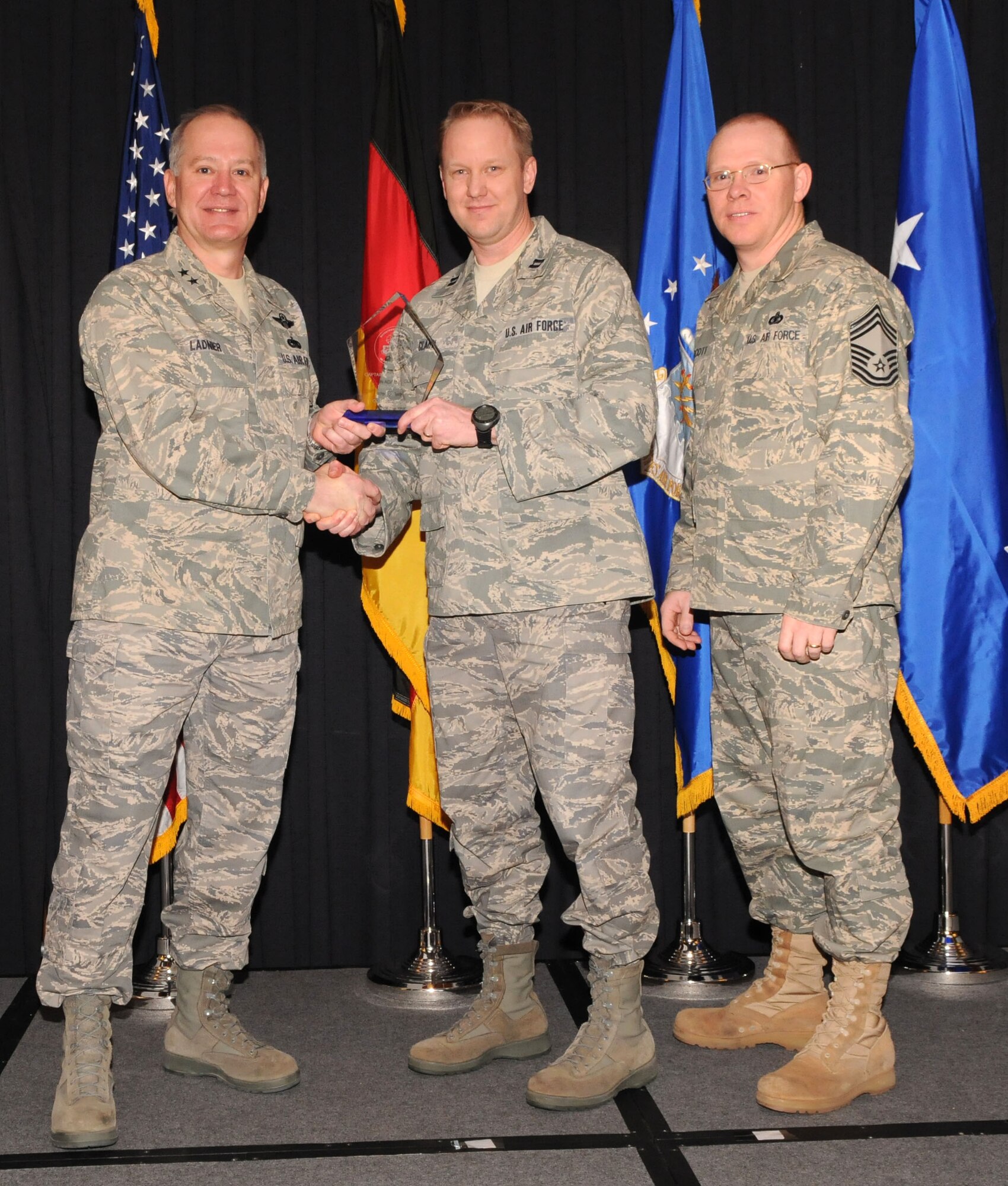 Maj. Gen. Ronald Ladnier, 17th Air Force Commander (left), and Chief Master Sgt. Steven Scott, acting 17th AF Command Chief (right), present the 2009 CGO of the Year award to Capt. Adam Clary, (A2), during the annual awards breakfast Feb. 9.