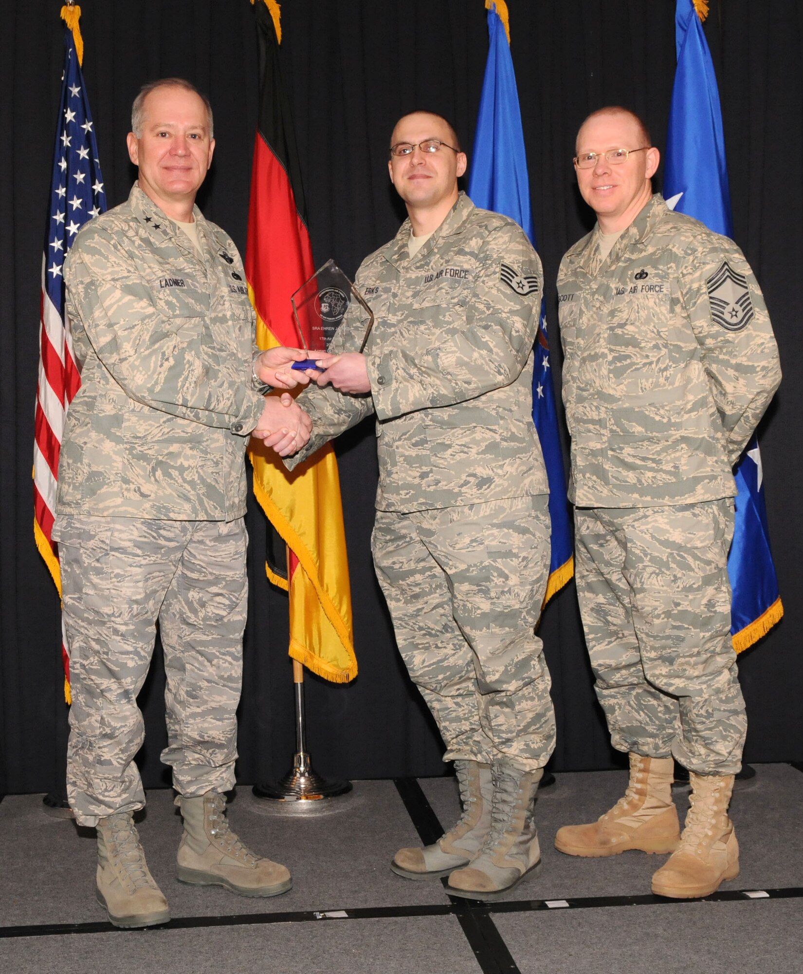 Maj. Gen. Ronald Ladnier, 17th Air Force Commander (left), and Chief Master Sgt. Steven Scott, acting 17th AF Command Chief (right), present the 2009 Airman of the Year award to Staff Sgt. Ehren Erks, (A6), during the annual awards breakfast Feb. 9.