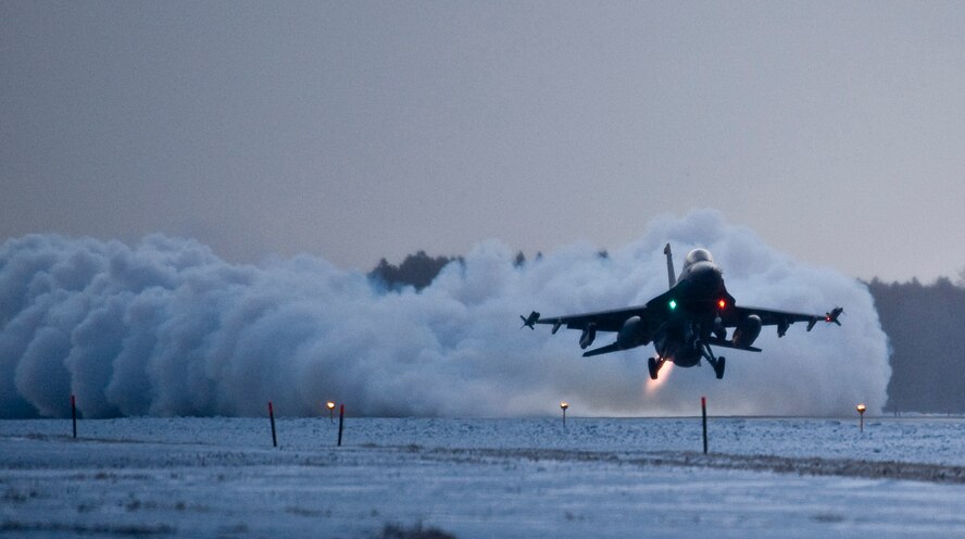 MISAWA AIR BASE, Japan -- Capt. Cory Farrer, 13th Fighter Squadron pilot, takes off in an F-16 Fighting Falcon before dawn on the final day of an operational readiness exercise Feb. 3. The jet's afterburners kicked up a plume of steam and snow as Captain Farrer lifted the nose of the F-16. (U.S. Air Force photo/Staff Sgt. Samuel Morse)