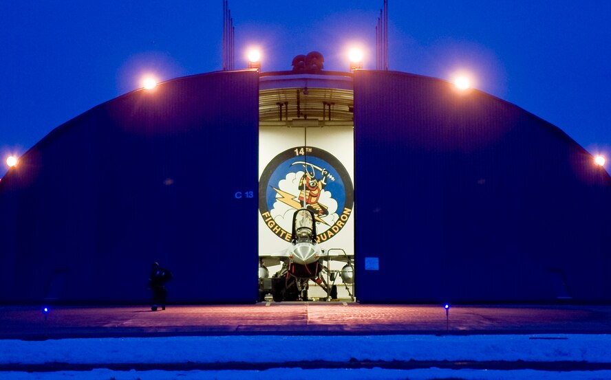 A partially open hardened aircraft shelter reveals an F-16 Fighting Falcon Feb. 1, 2010, at Misawa Air Base, Japan. The emblem of the 14th Fighter Squadron is displayed on the wall behind the jet featuring a samurai riding a lightning bolt. (U.S. Air Force photo/Staff Sgt. Samuel Morse) 