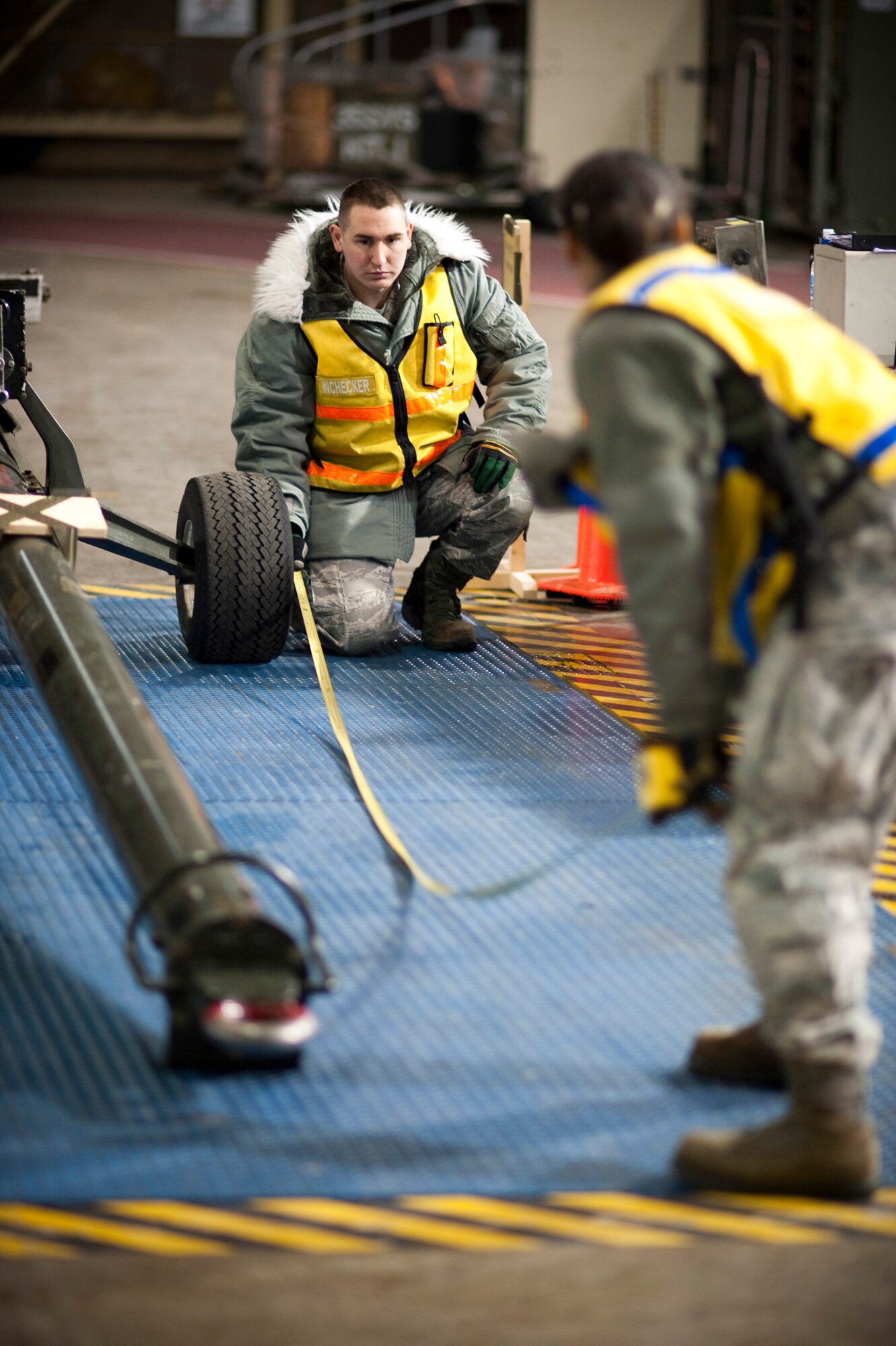 MISAWA AIR BASE, Japan -- Senior Airman Nicole Smith, 35th Logistics Readiness Squadron and Airman 1st Class Benjamin Emmons, cargo deployment function clerks, measure the length of a tow bar inside Hangar 949 during an operational readiness exercise Jan. 28. The equipment must be weighed and measured before it can be loaded into an aircraft so the loadmaster can properly place the equipment once the dimensions are calculated. (U.S. Air Force photo/Staff Sgt. Samuel Morse)